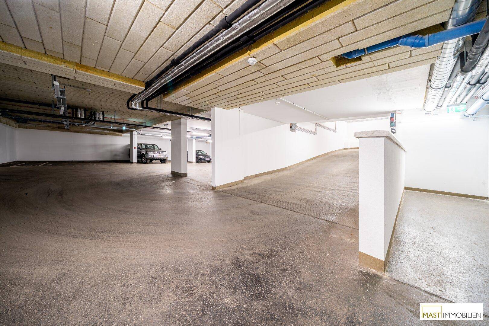 Tiefgarage mit Zufahrtsrampe und ausreichend Stellplätzen für Fahrzeuge.