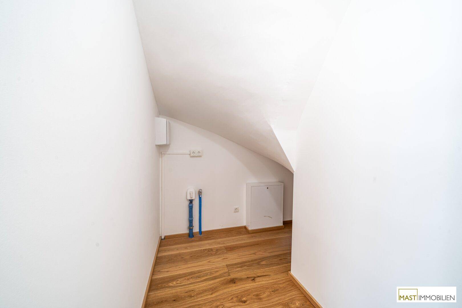 Praktischer Abstellraum mit Anschlüssen und schräger Decke.