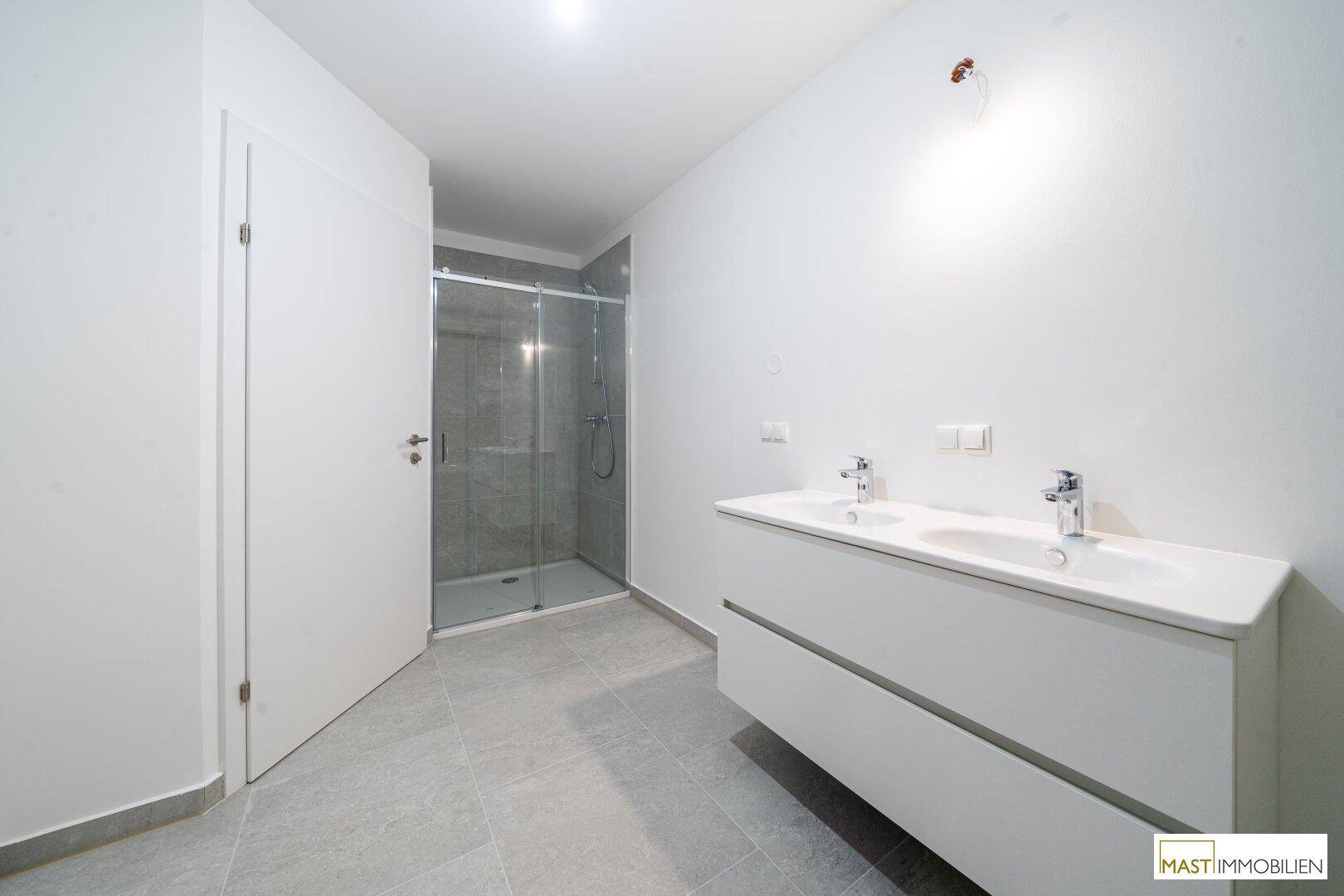 Modernes Badezimmer mit Doppelwaschbecken und separater Duschkabine.