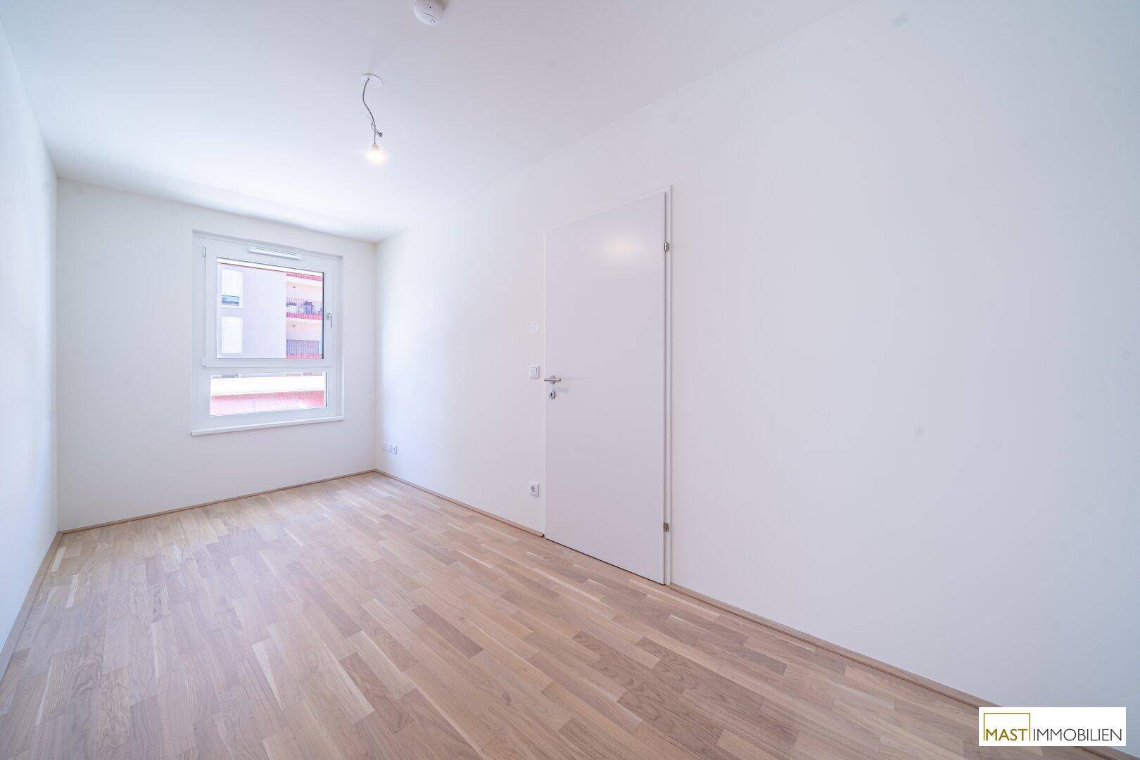 Weiteres helles Zimmer mit Eichenparkett und Fenster, ideal als Schlaf- oder Arbeitszimmer.