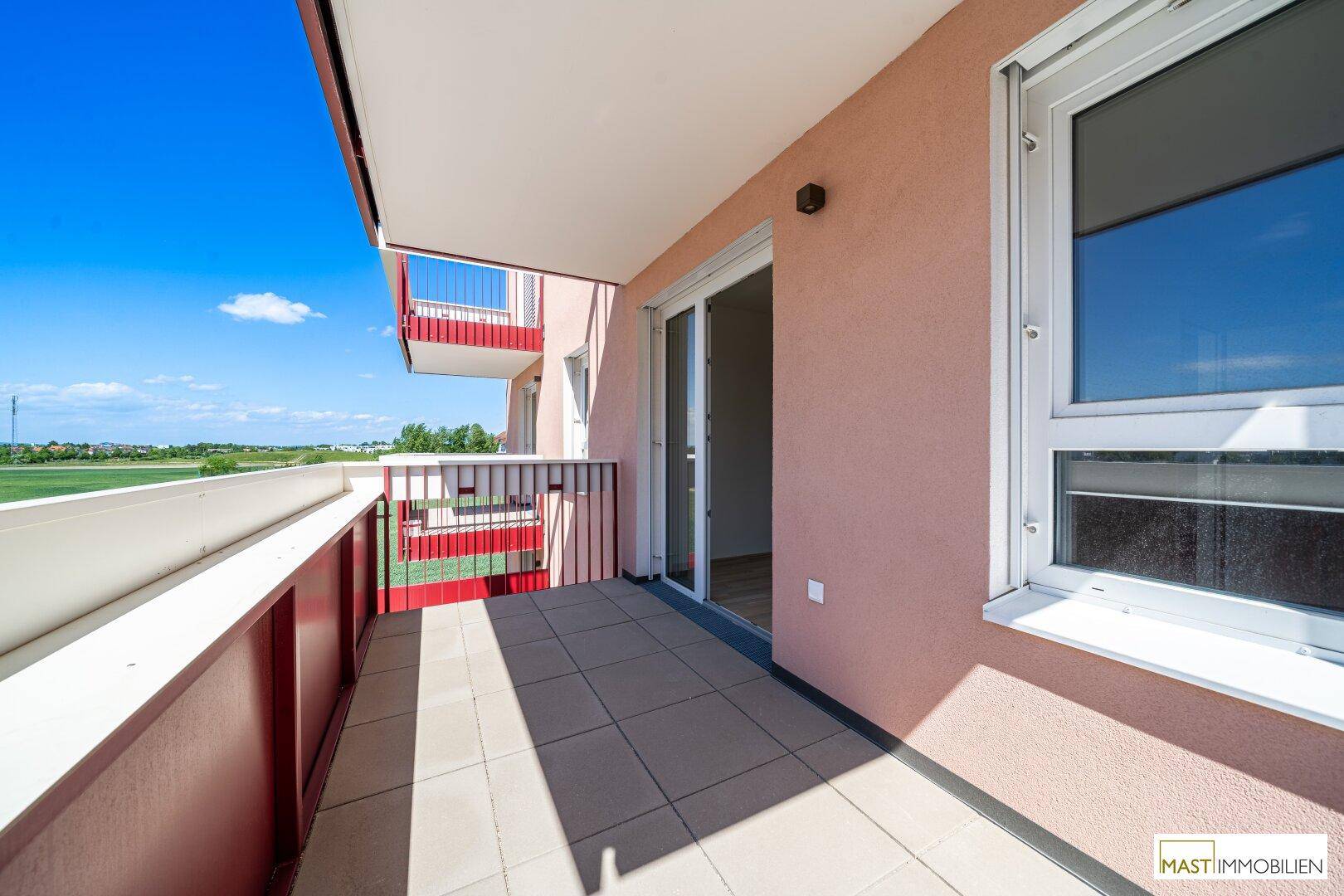 Balkon mit Fliesenboden und Schiebetür zum Innenbereich, ideal für entspannte Stunden.