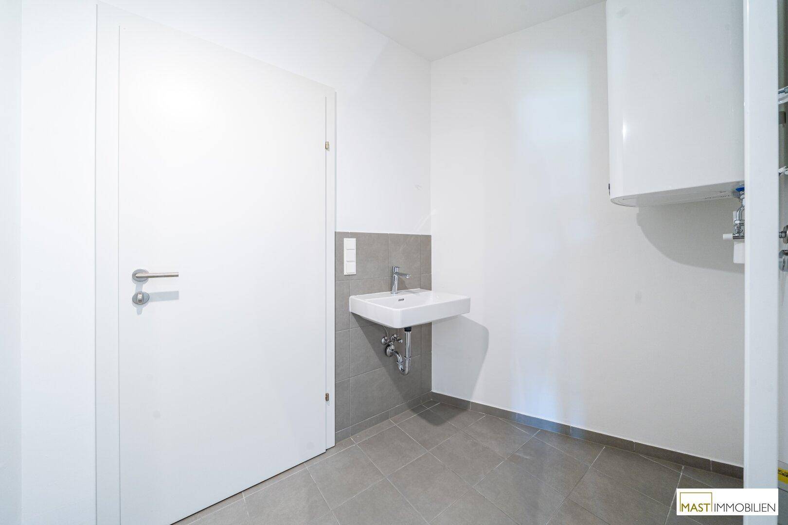 Kleines Badezimmer mit Waschbecken und Fliesenboden, ideal als Gäste-WC.