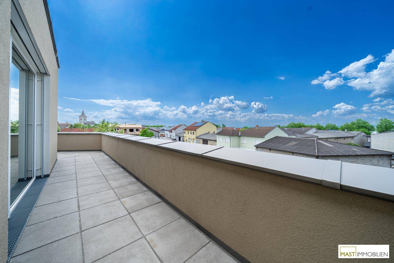 Geräumige Dachterrasse mit Fliesenboden und weitem Blick über die Dächer der Stadt.