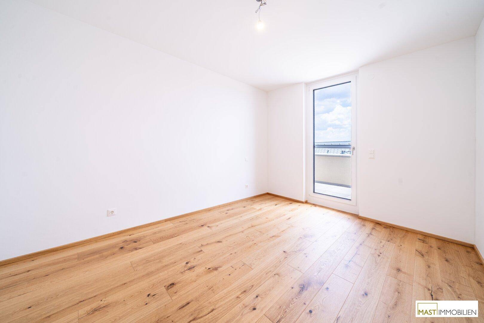 Geräumiges Schlafzimmer mit Holzboden und Fenster, ideal für ein ruhiges Ambiente.