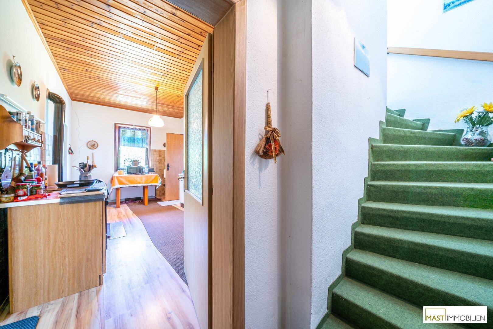 Flur mit Zugang zur Küche und einer Treppe, die in die obere Etage führt.