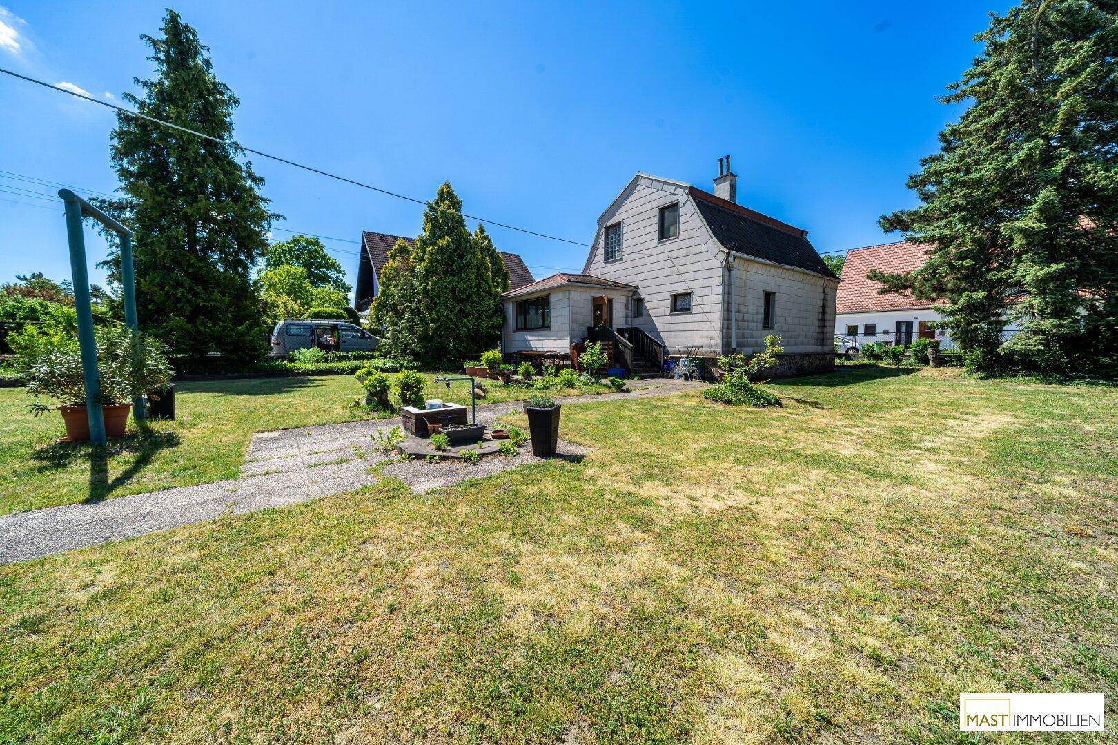 Großer, gepflegter Gartenbereich mit Rasenfläche und dem Einfamilienhaus im Hintergrund.