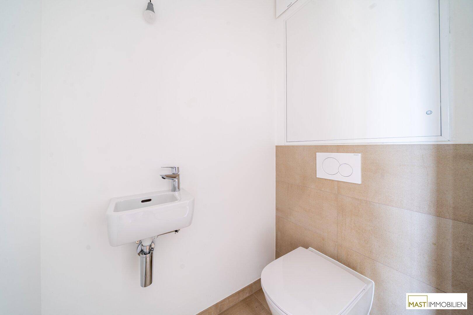 Funktionelles Gäste-WC mit wandhängender Toilette und kleinem Handwaschbecken, praktisch und modern.