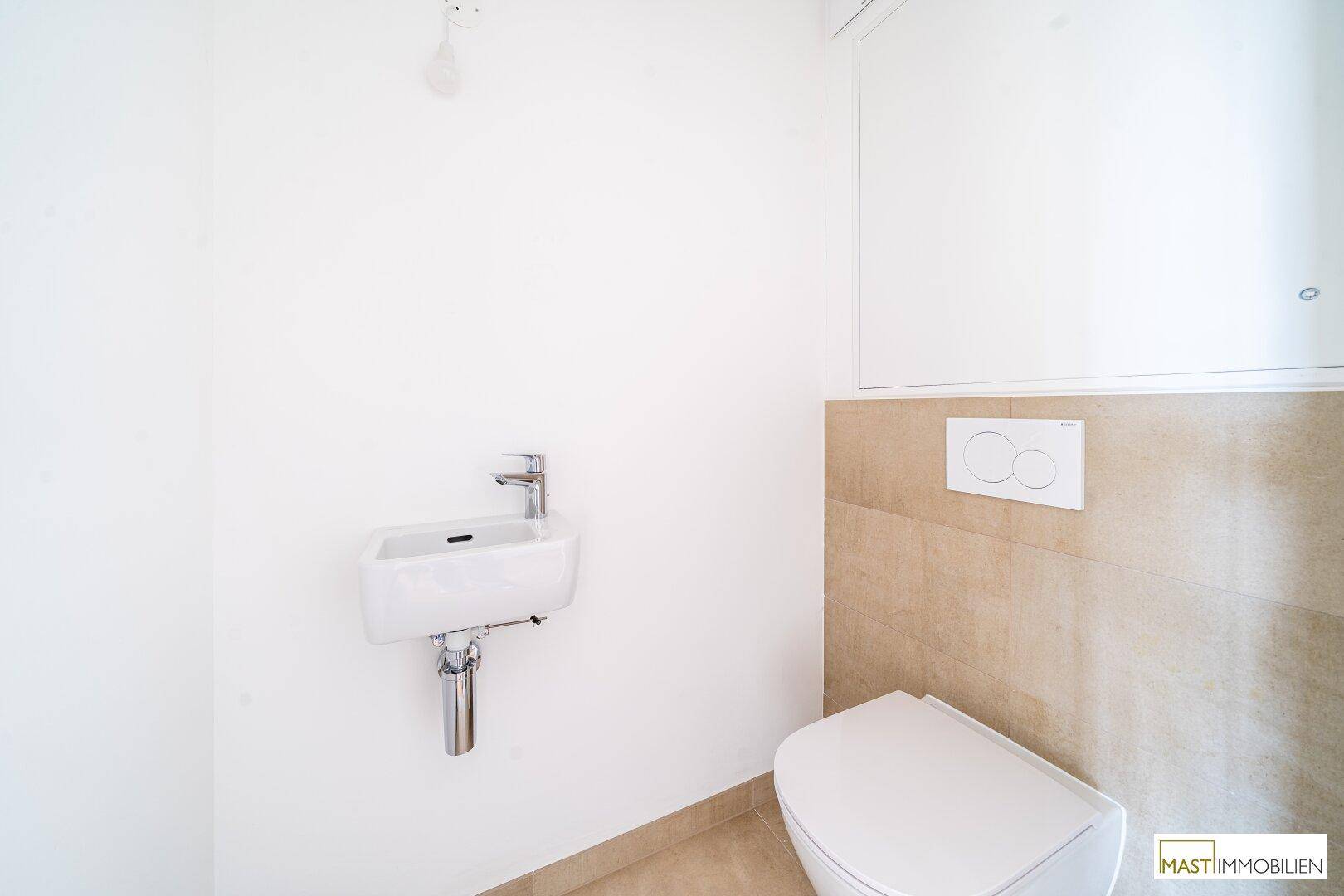 Kleines Gäste-WC mit wandhängender Toilette und kompaktem Waschbecken, in schlichtem Design.