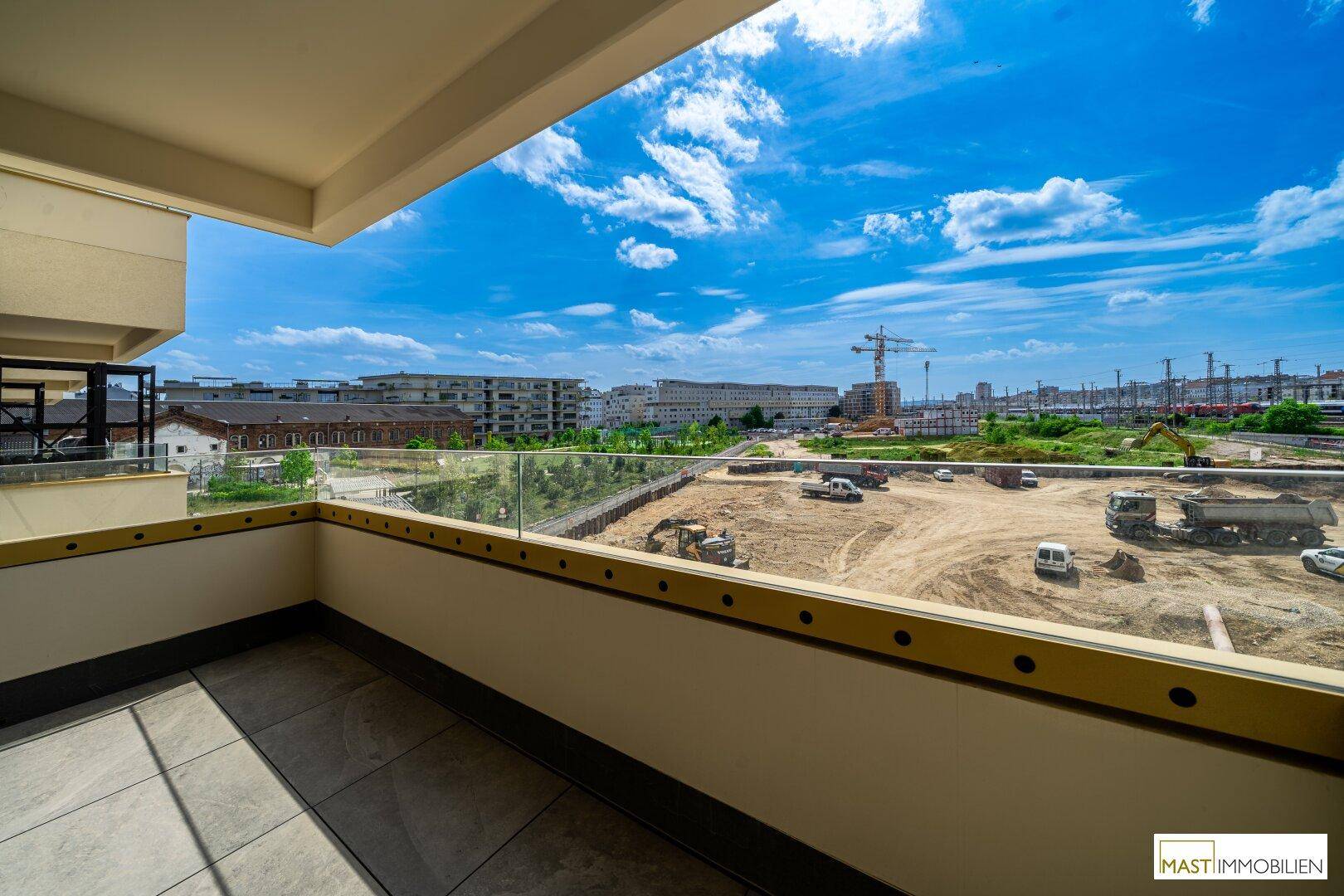 Unmöblierte Terrasse mit Fliesenboden und Panoramablick auf die städtische Umgebung und Baustellen.