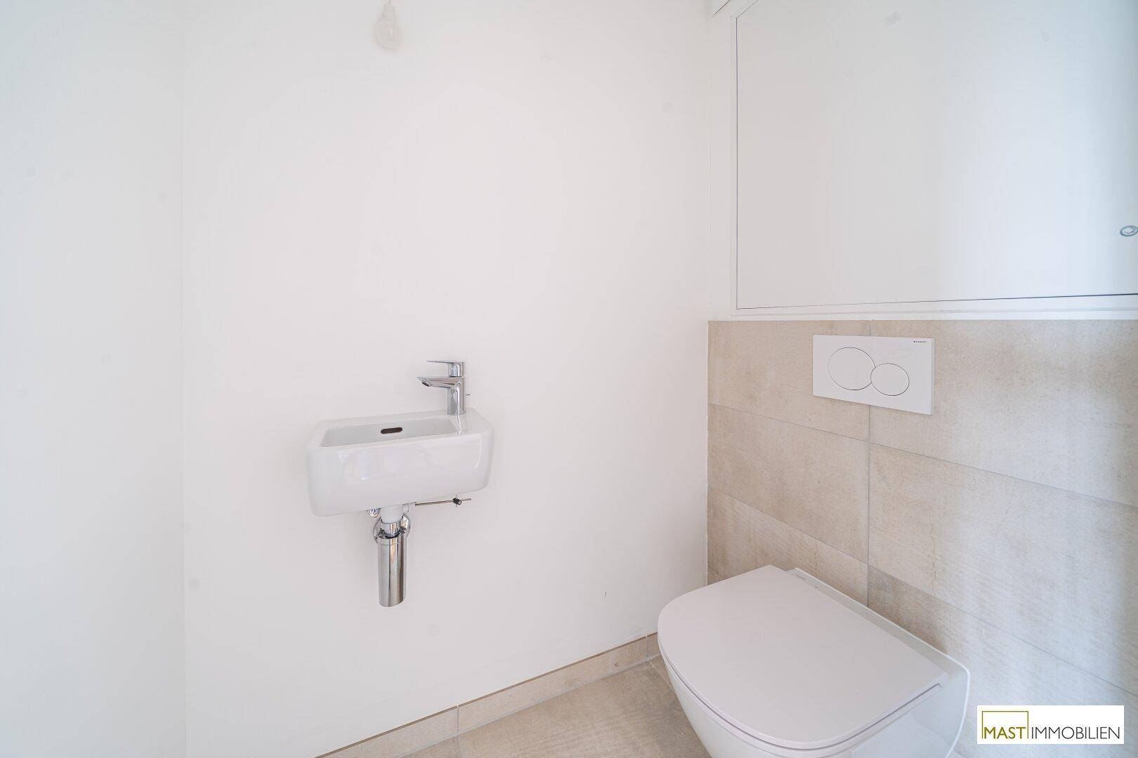Kleines Gäste-WC mit wandhängender Toilette und kompaktem Waschbecken, in modernem Design.