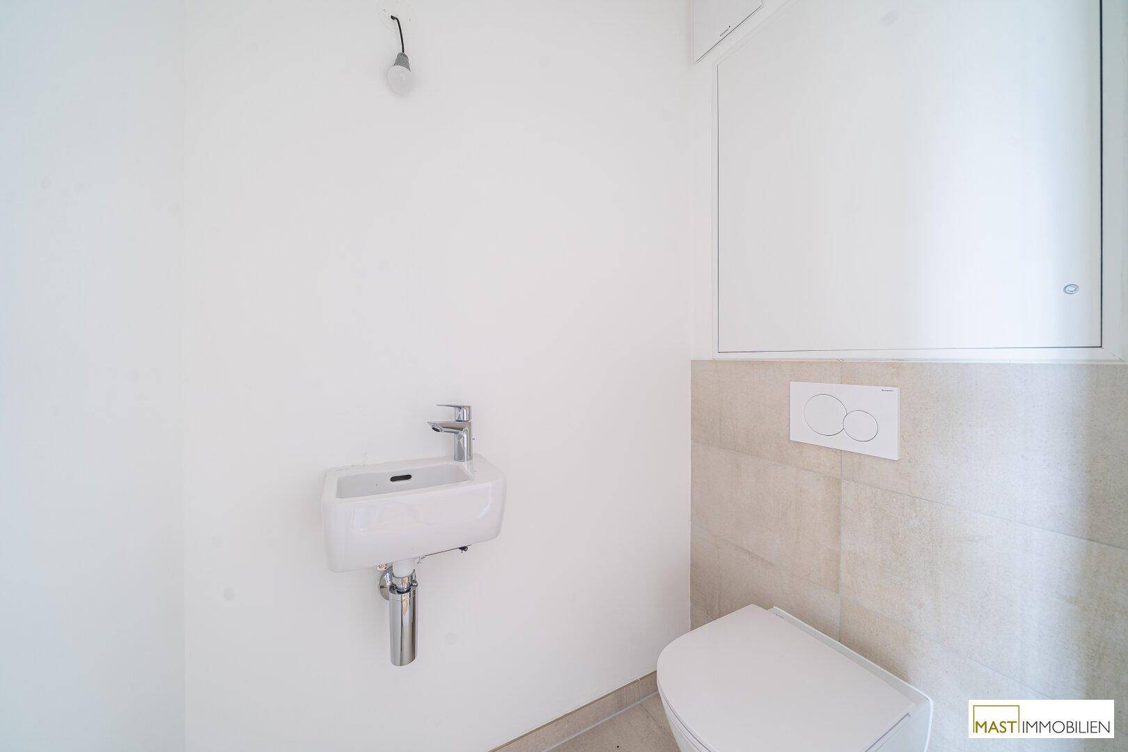 Kleines Gäste-WC mit wandhängender Toilette und kompaktem Waschbecken, funktional und hell.