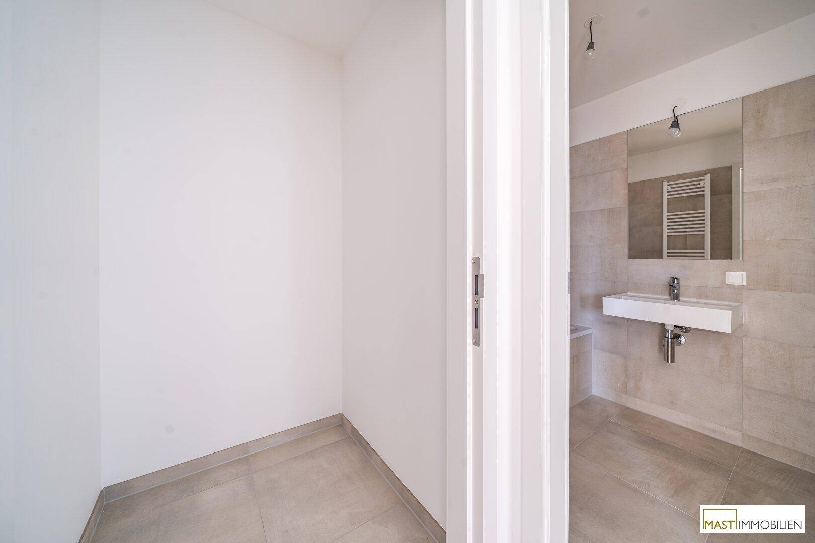 Blick in ein modernes Badezimmer mit hellen Fliesen und zeitgemäßer Ausstattung.