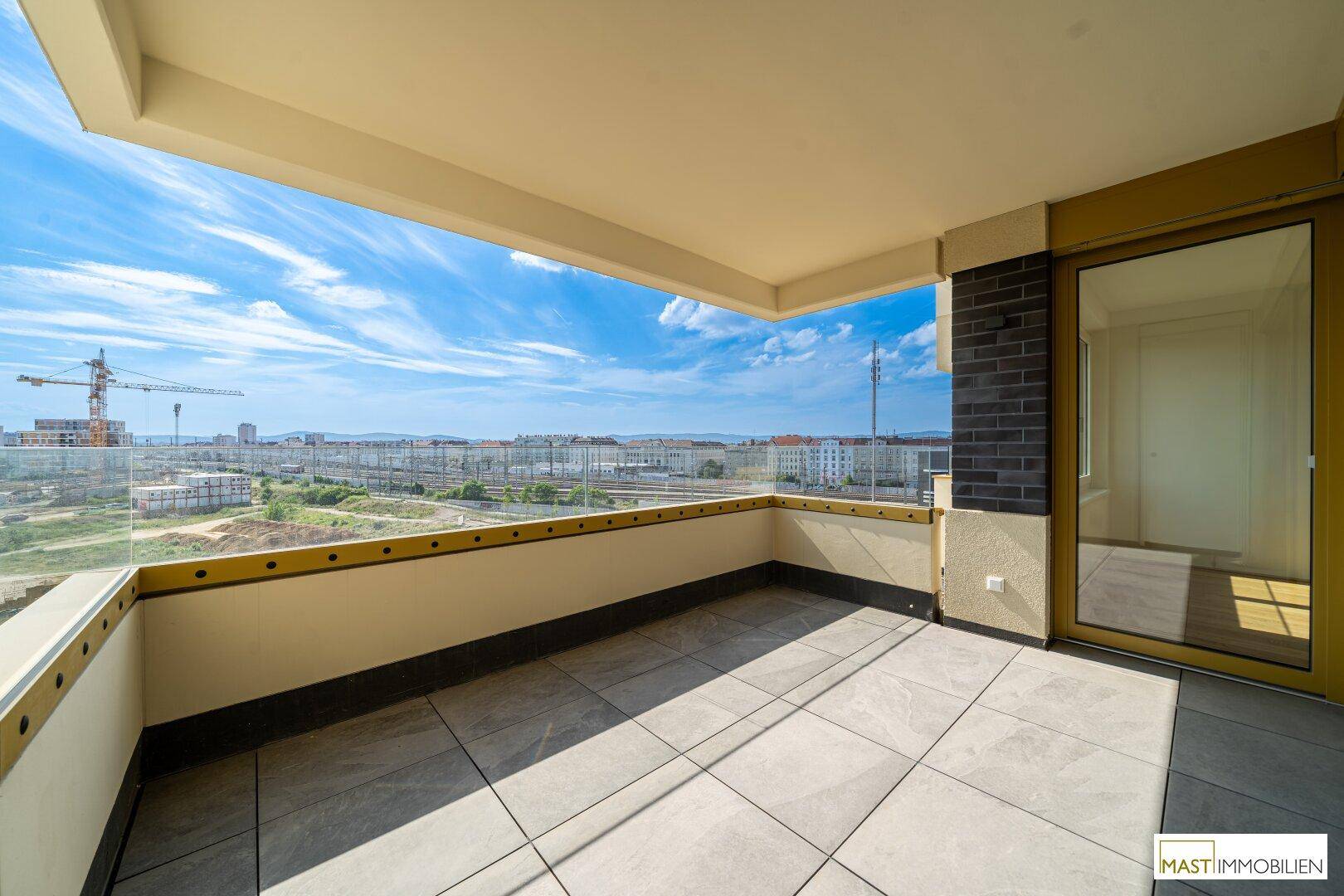 Großzügige Terrasse mit Fliesenboden und weitem Blick über die Stadtlandschaft.