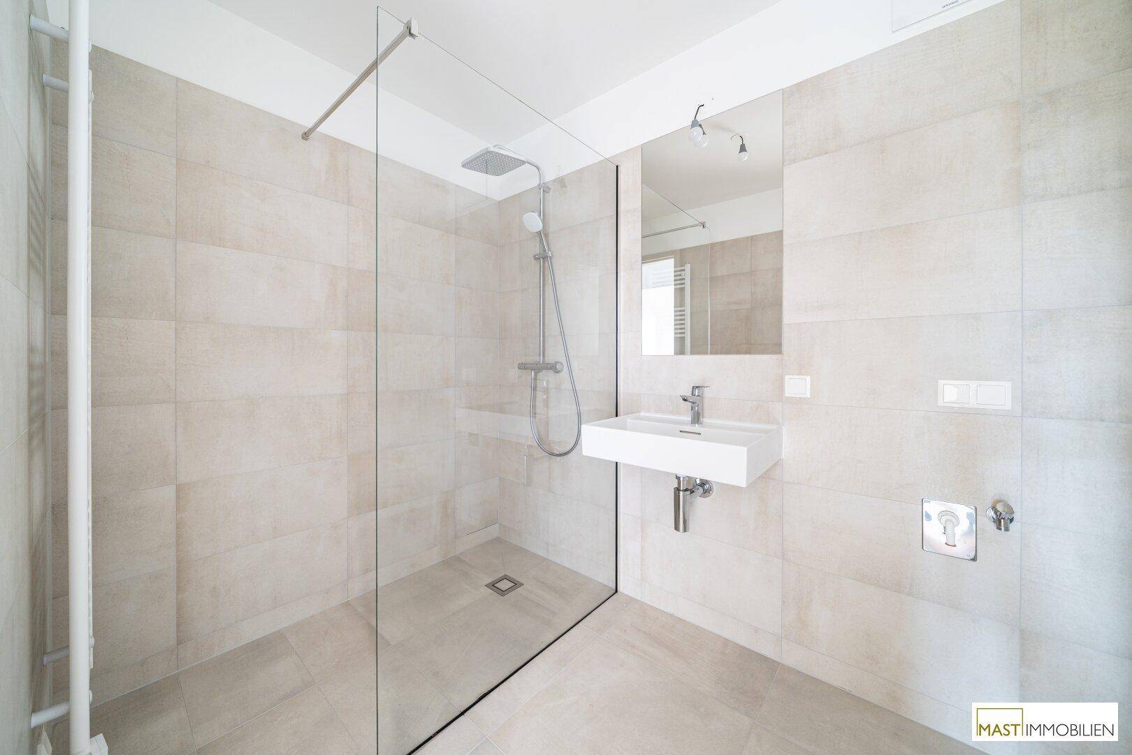 Modernes Badezimmer mit begehbarer Dusche, eleganten Fliesen und schwebendem Waschbecken.