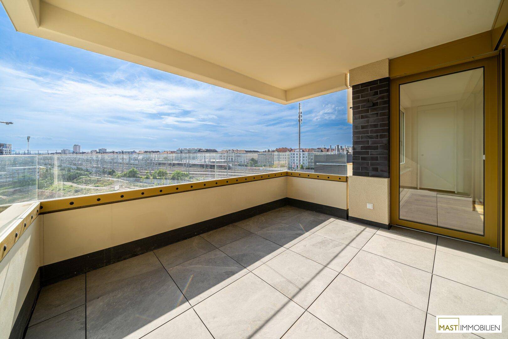 Weitläufige Terrasse mit modernem Glasgeländer und Panoramablick über die städtische Umgebung.
