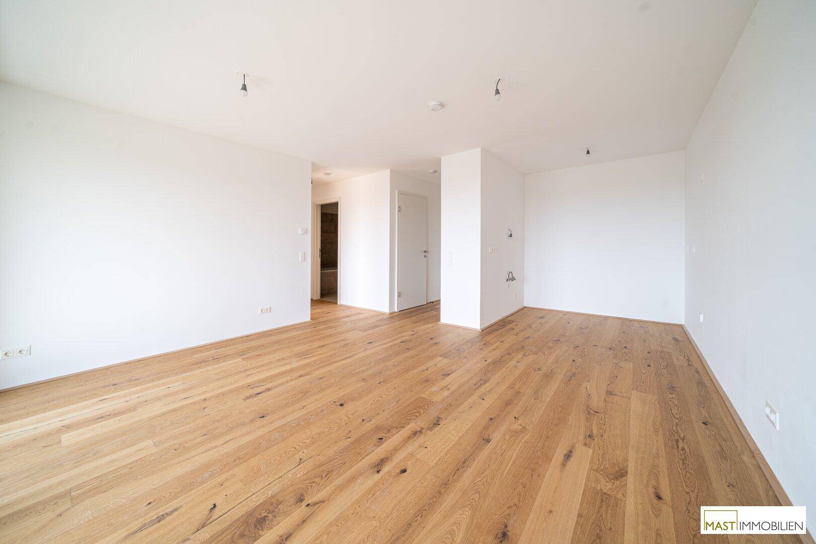 Heller Flur mit Holzboden, der zu verschiedenen Räumen führt und einen offenen Eindruck vermittelt.