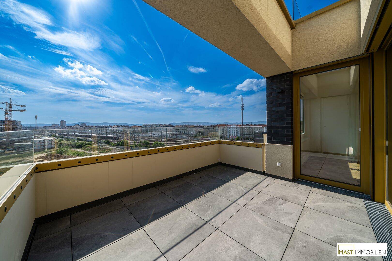 Geräumige Dachterrasse mit Fliesenboden und weitem Blick über die Stadt und die Umgebung.