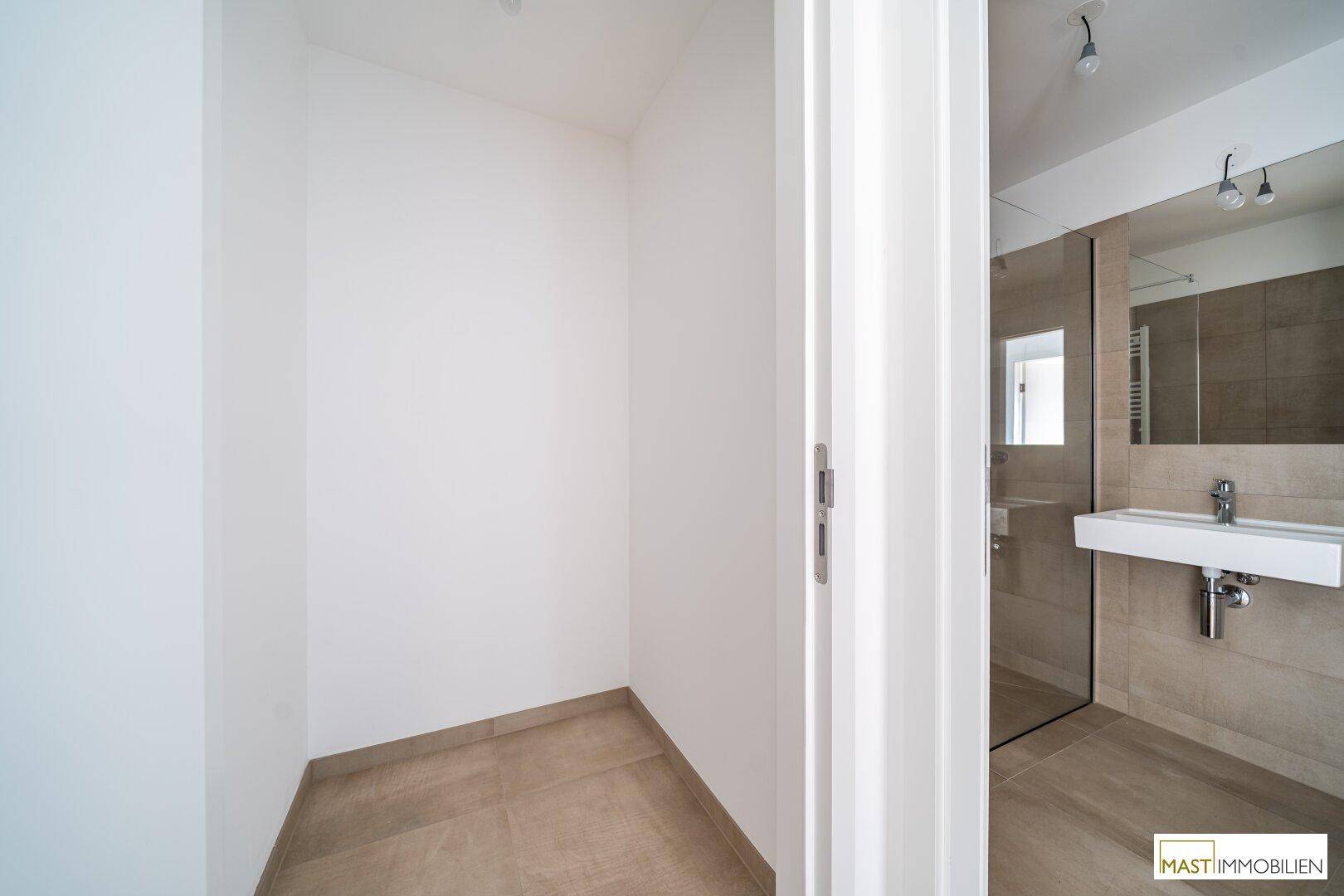 Praktischer Abstellraum mit Fliesenboden, direkt neben dem modernen Badezimmer gelegen.