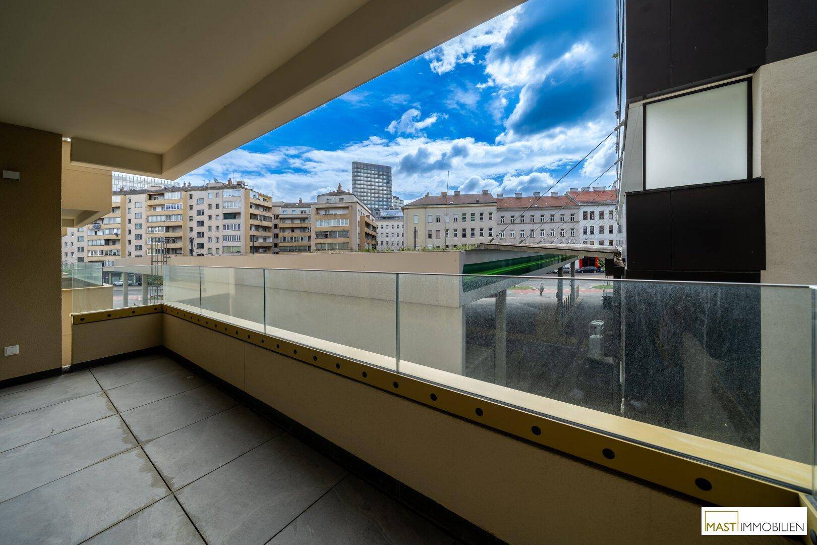 Balkon mit Glasgeländer und Stadtblick, der einen angenehmen Außenbereich bietet.