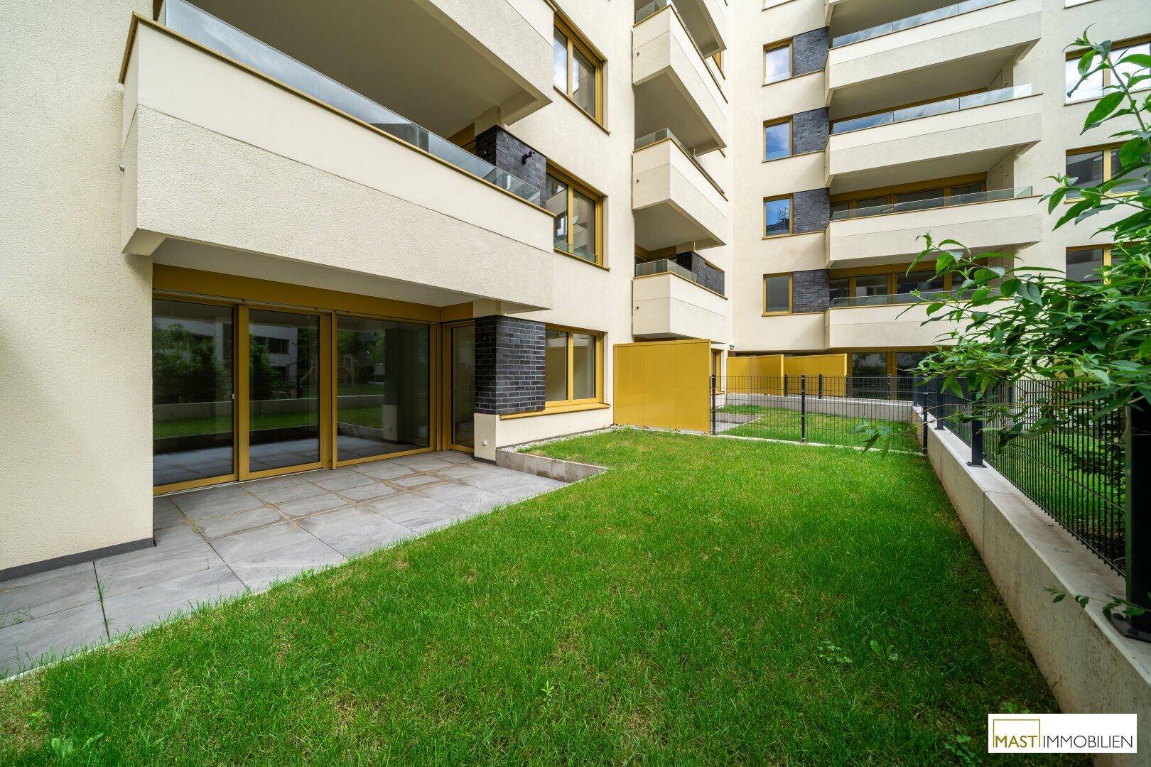 Erdgeschosswohnung mit privater Terrasse und direktem Zugang zu einem kleinen Gartenbereich.