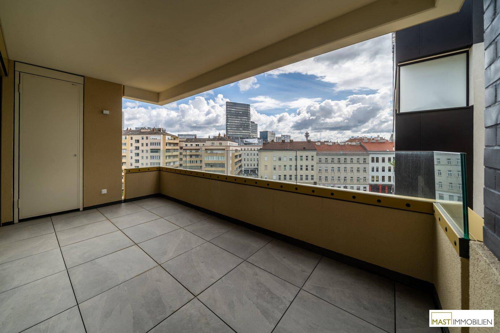 Geräumiger Balkon mit Fliesenboden und weitem Blick über die Stadt, ideal zum Entspannen.