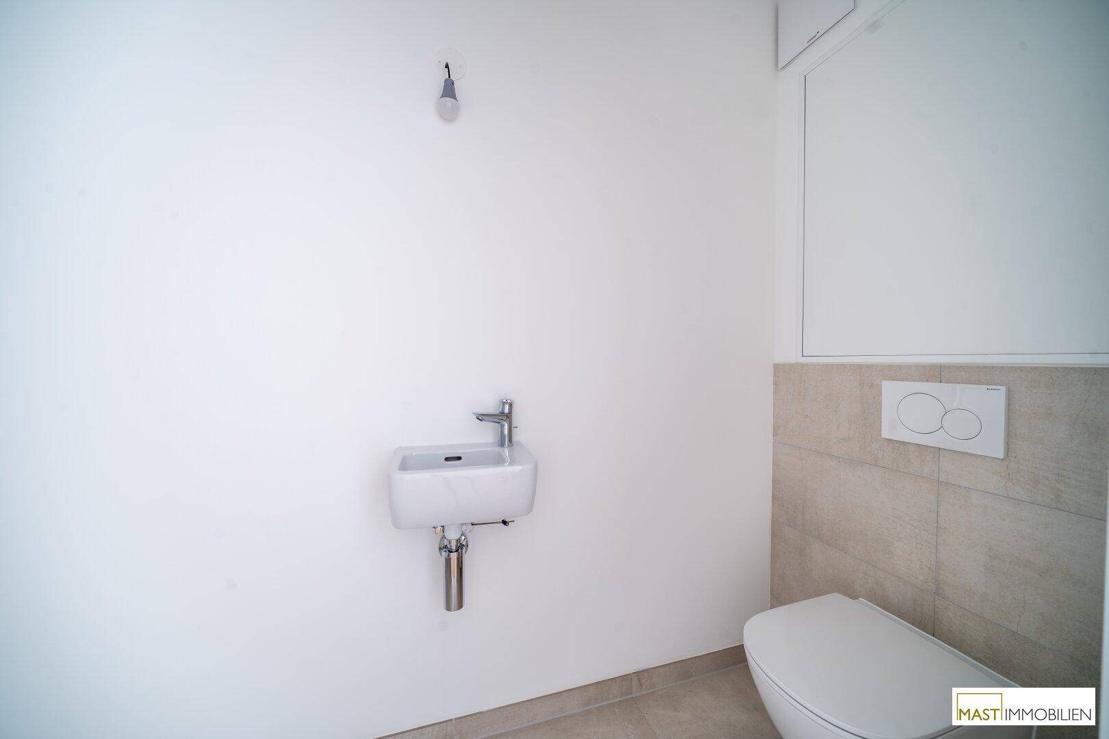 Modernes Gäste-WC mit Wand-WC und kleinem Waschbecken in neutralen Farben.
