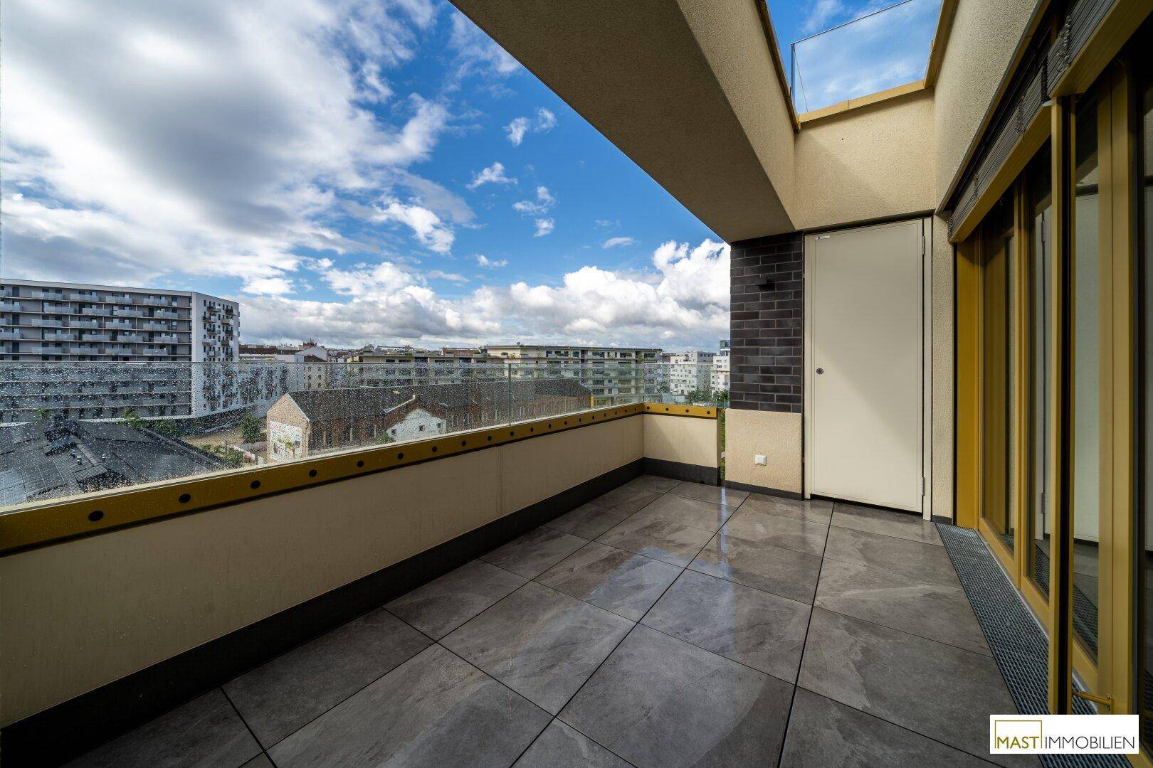 Großer Balkon mit Fliesenboden und Glasbrüstung bietet weite Aussicht.