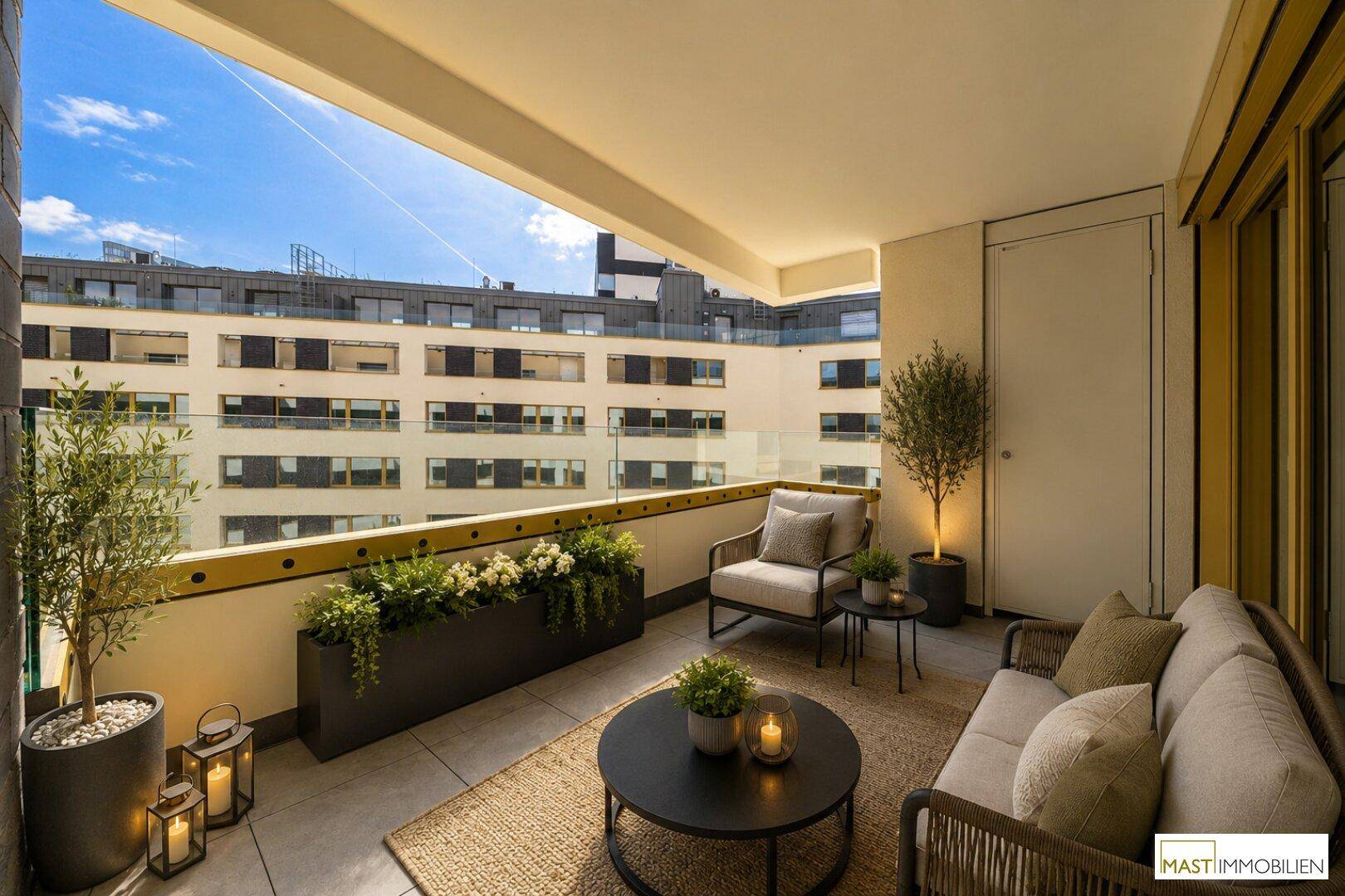 Möblierter Balkon mit Pflanzen und Blick auf die umliegenden Gebäude.