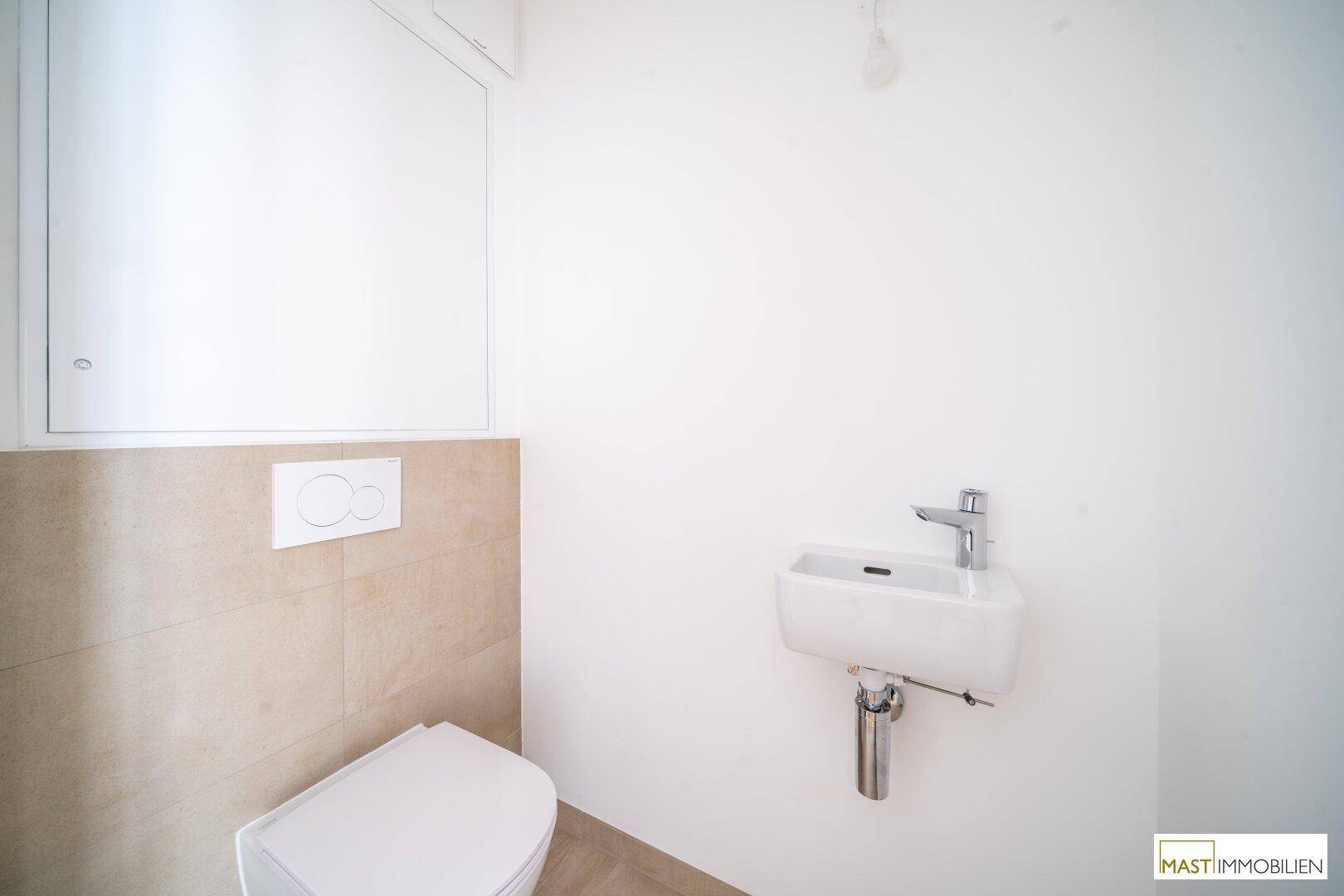Kleines Gäste-WC mit modernem Wand-WC und Handwaschbecken, in hellem Design.