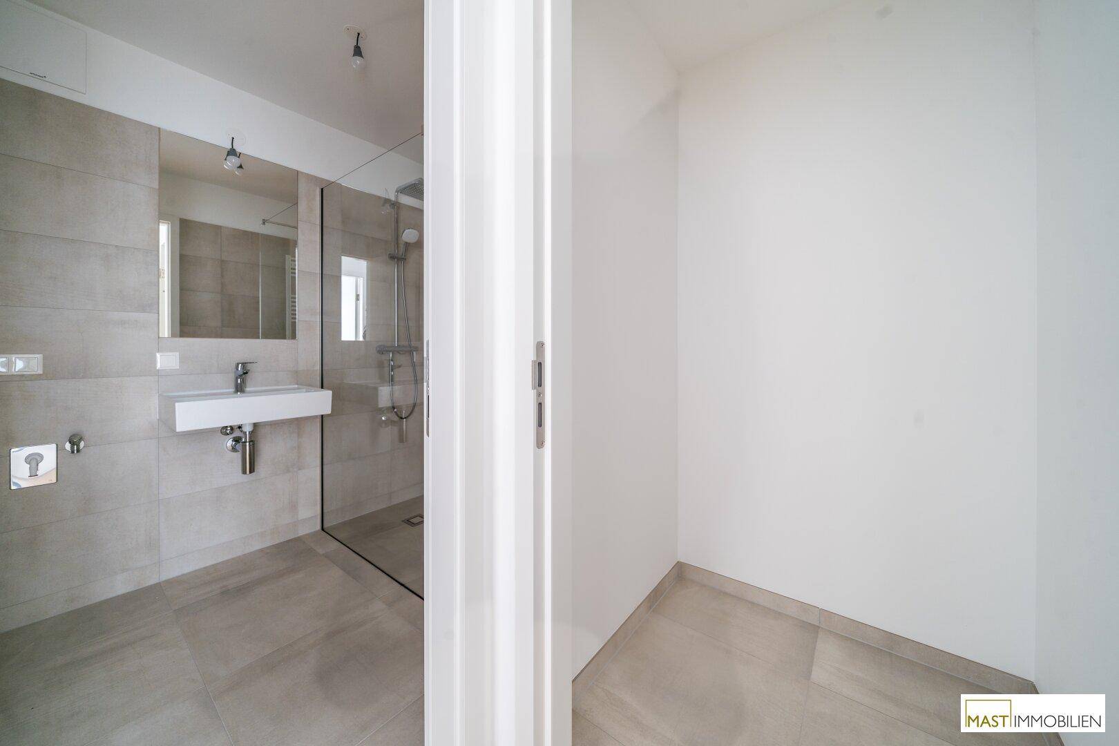 Modernes Badezimmer mit begehbarer Dusche, Fliesenboden und minimalistischem Design.