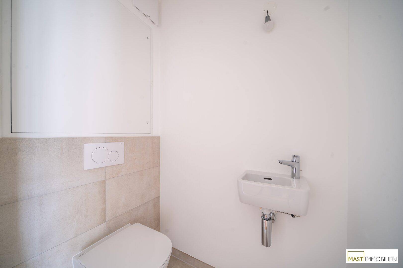 Kleines Gäste-WC mit wandhängender Toilette und kompaktem Waschbecken in modernem Design.