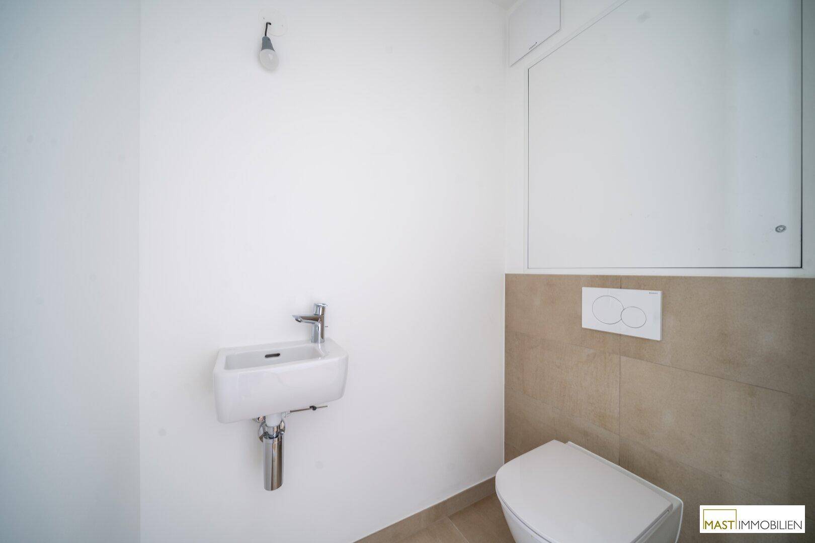 Modernes Gäste-WC mit wandhängendem WC und kleinem Waschbecken.