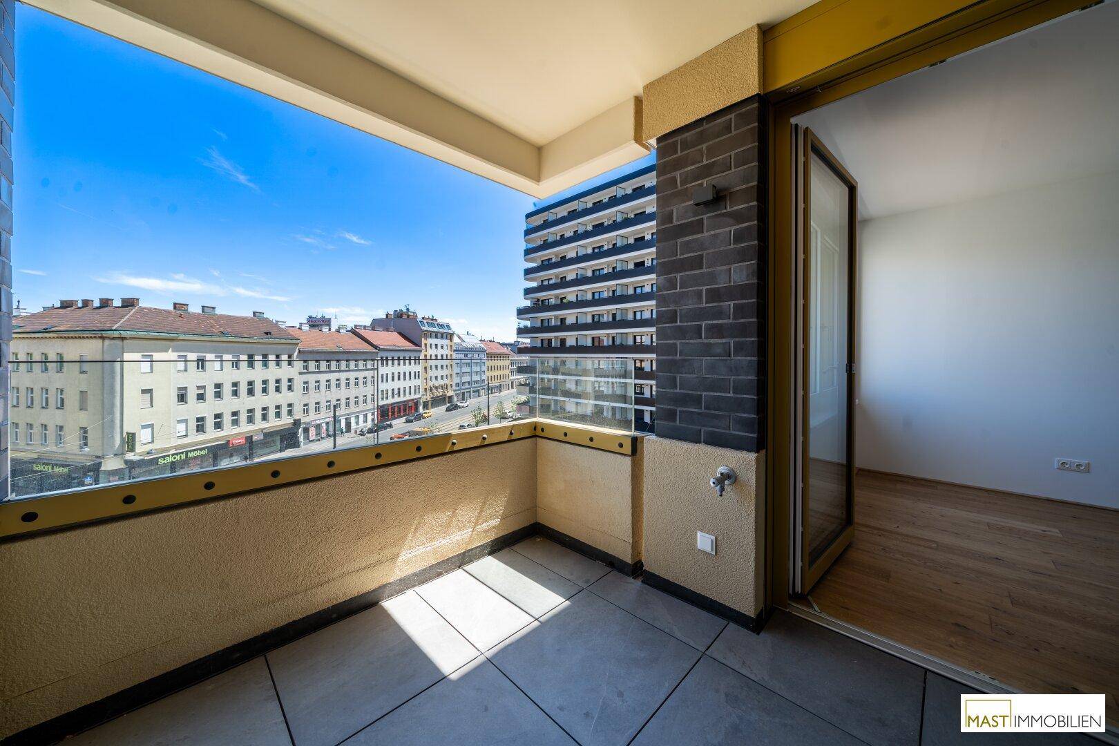 Sonniger Balkon mit Stadtblick und Fliesenboden, ideal für entspannte Stunden im Freien.