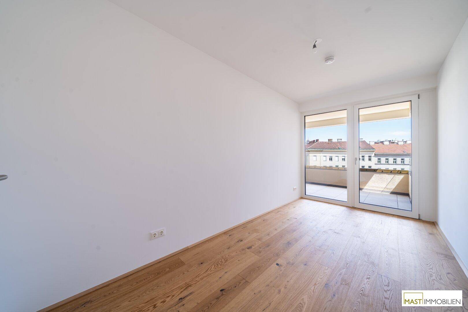 Helles Schlafzimmer mit Hartholzboden und direktem Zugang zu einem privaten Balkon mit Stadtblick.