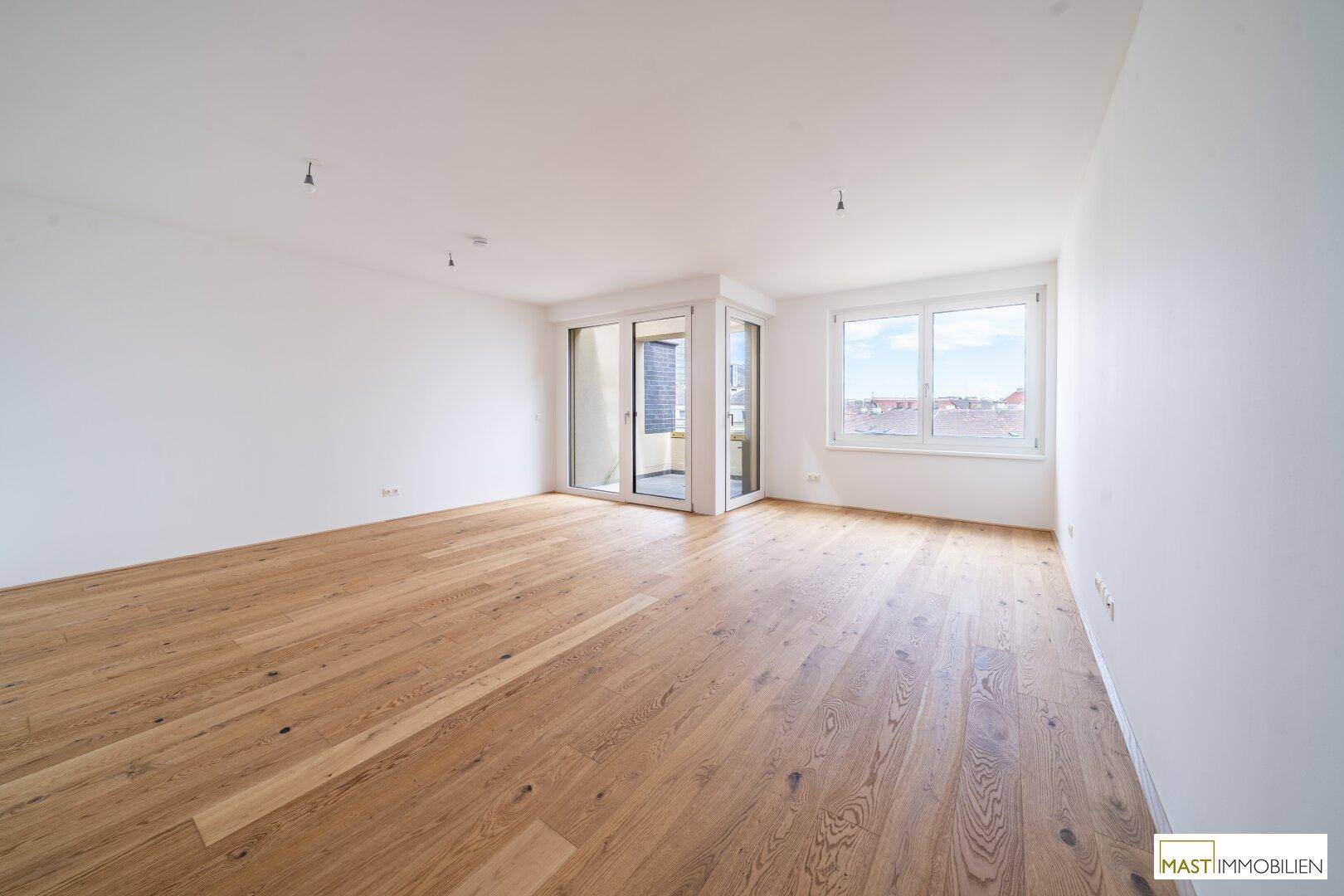 Lichtdurchfluteter Wohnraum mit Holzboden und Eckbalkon, ideal für entspannte Stunden.