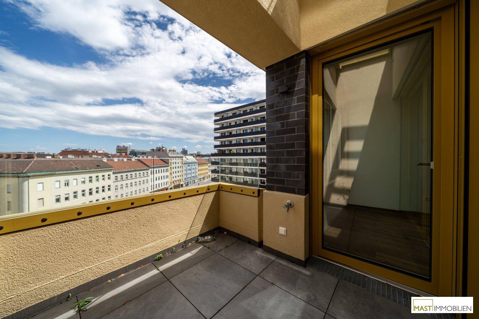 Sonniger Balkon mit Fliesenboden und Stadtblick, perfekt für Outdoor-Entspannung.