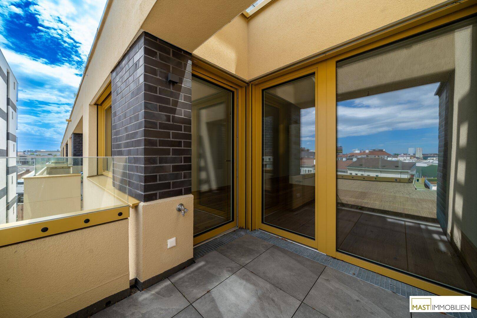 Heller Eckbalkon mit Fliesenboden und weitem Stadtblick, ideal für sonnige Tage.
