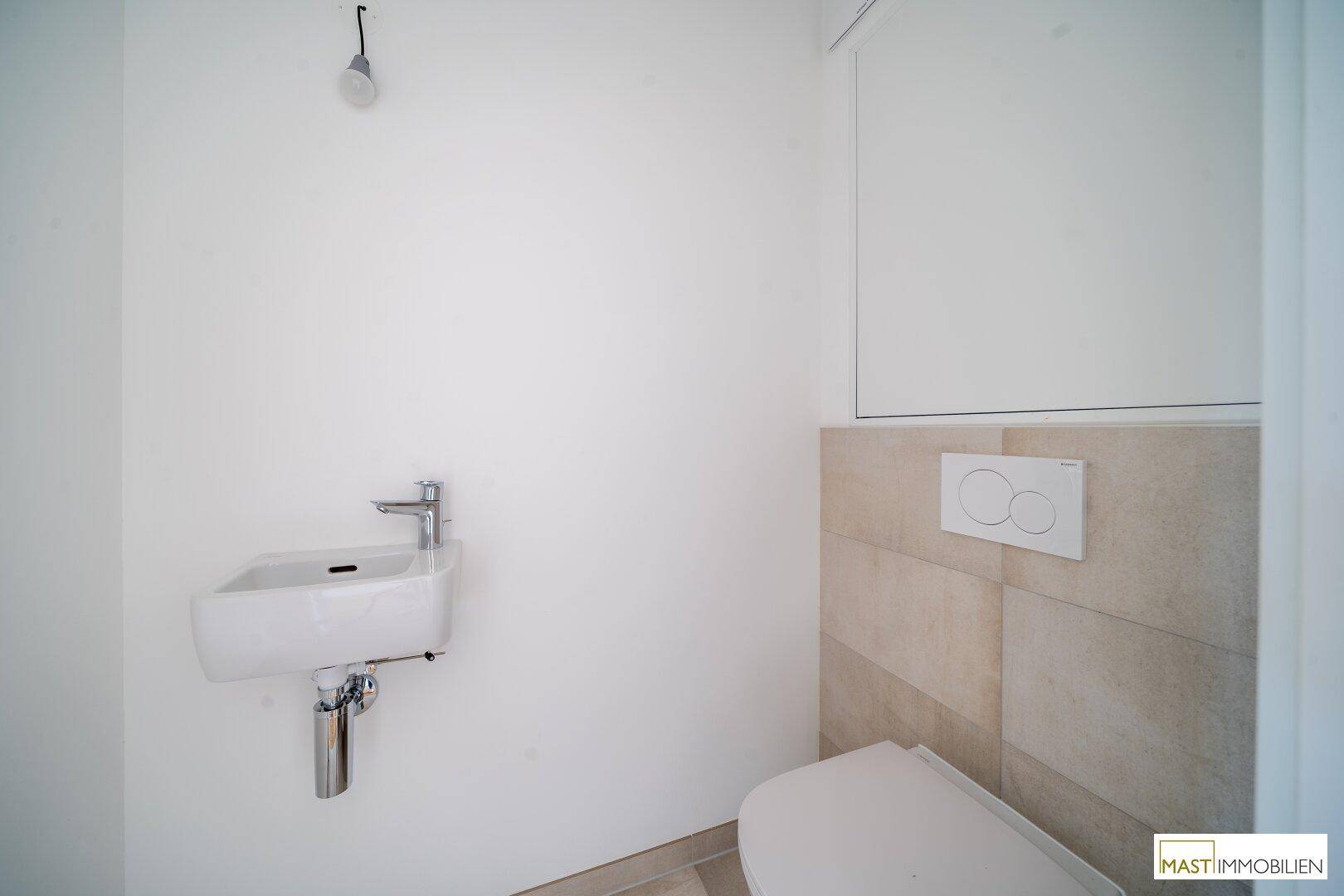 Modernes Gäste-WC mit wandhängendem WC und kleinem Waschbecken, hell gefliest.