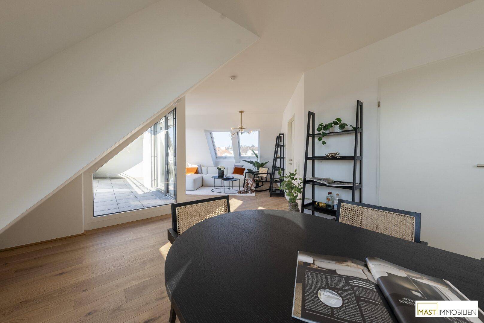 Offener Wohn- und Essbereich mit Holzboden, modernen Möbeln und Zugang zur Dachterrasse.