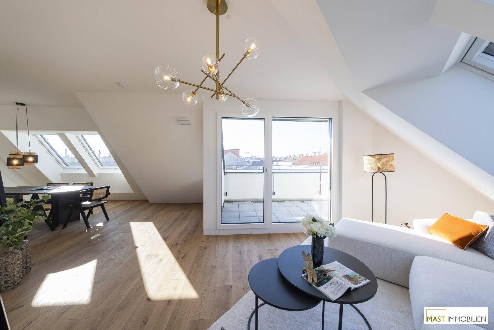 Heller offener Wohn- und Essbereich mit Holzboden und Zugang zu einer sonnigen Dachterrasse.