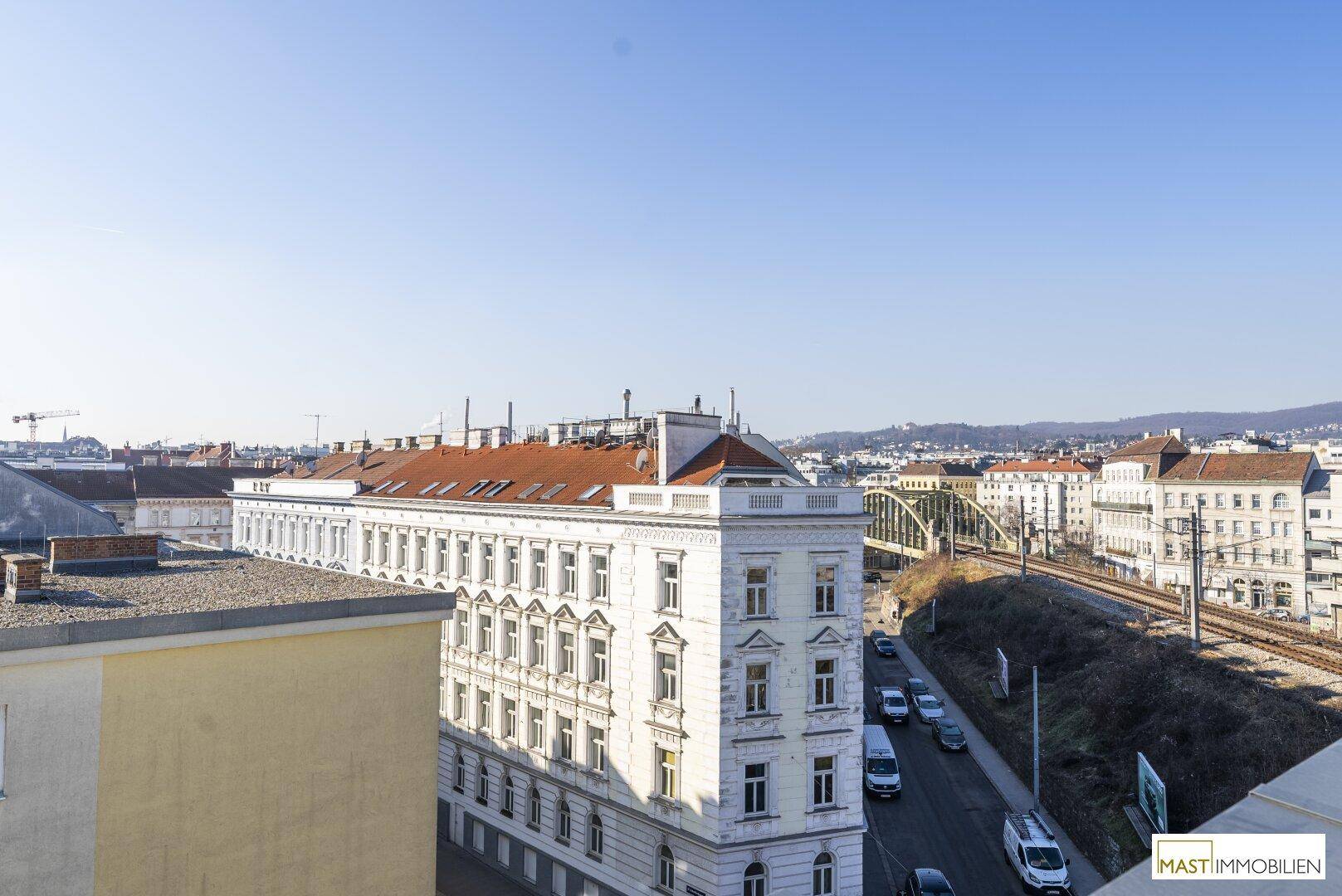 Panoramablick über die Stadt mit historischen Gebäuden und einer Brücke im Hintergrund.