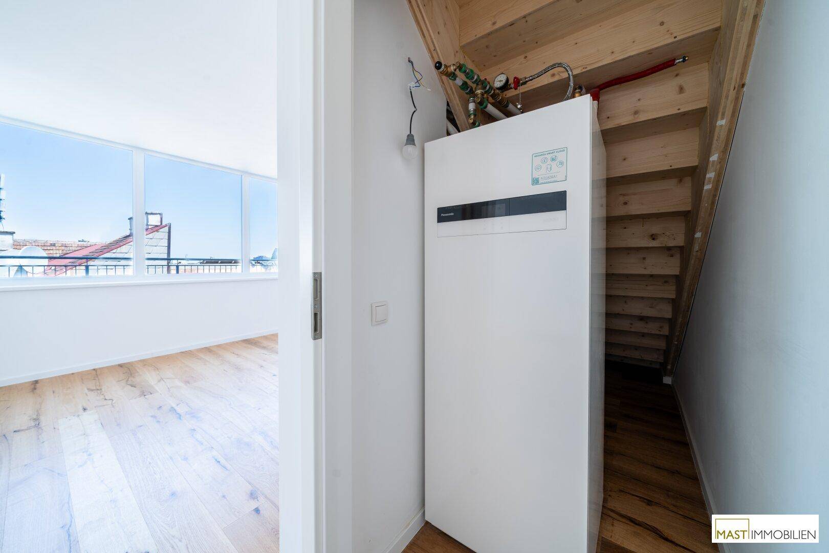 Praktischer Hauswirtschaftsraum unter der Treppe mit Heizungsanlage und Stauraum, effizient genutzt.