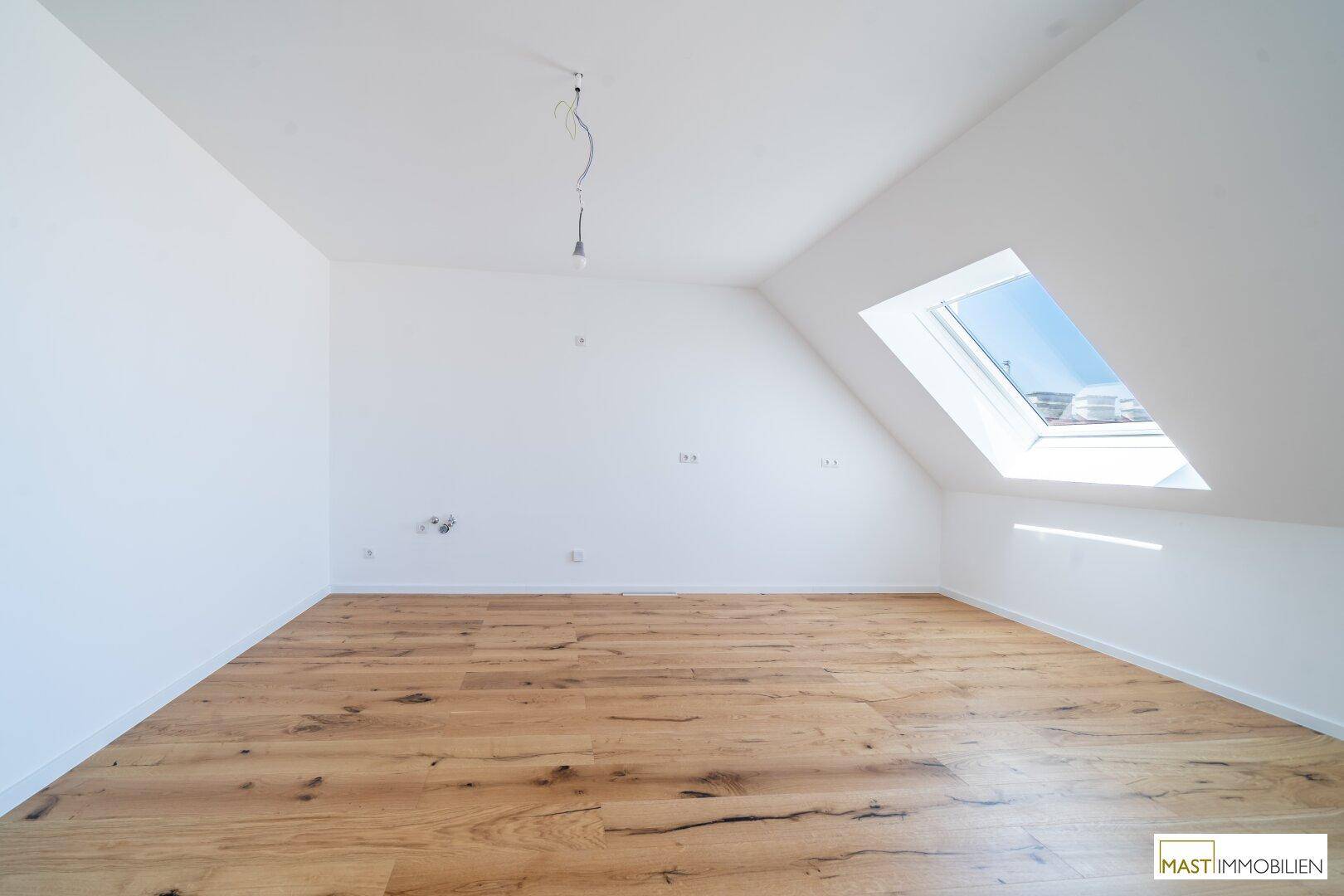 Geräumiger Raum mit Holzboden und einem Dachfenster, bietet viel Potenzial für individuelle Gestaltung.