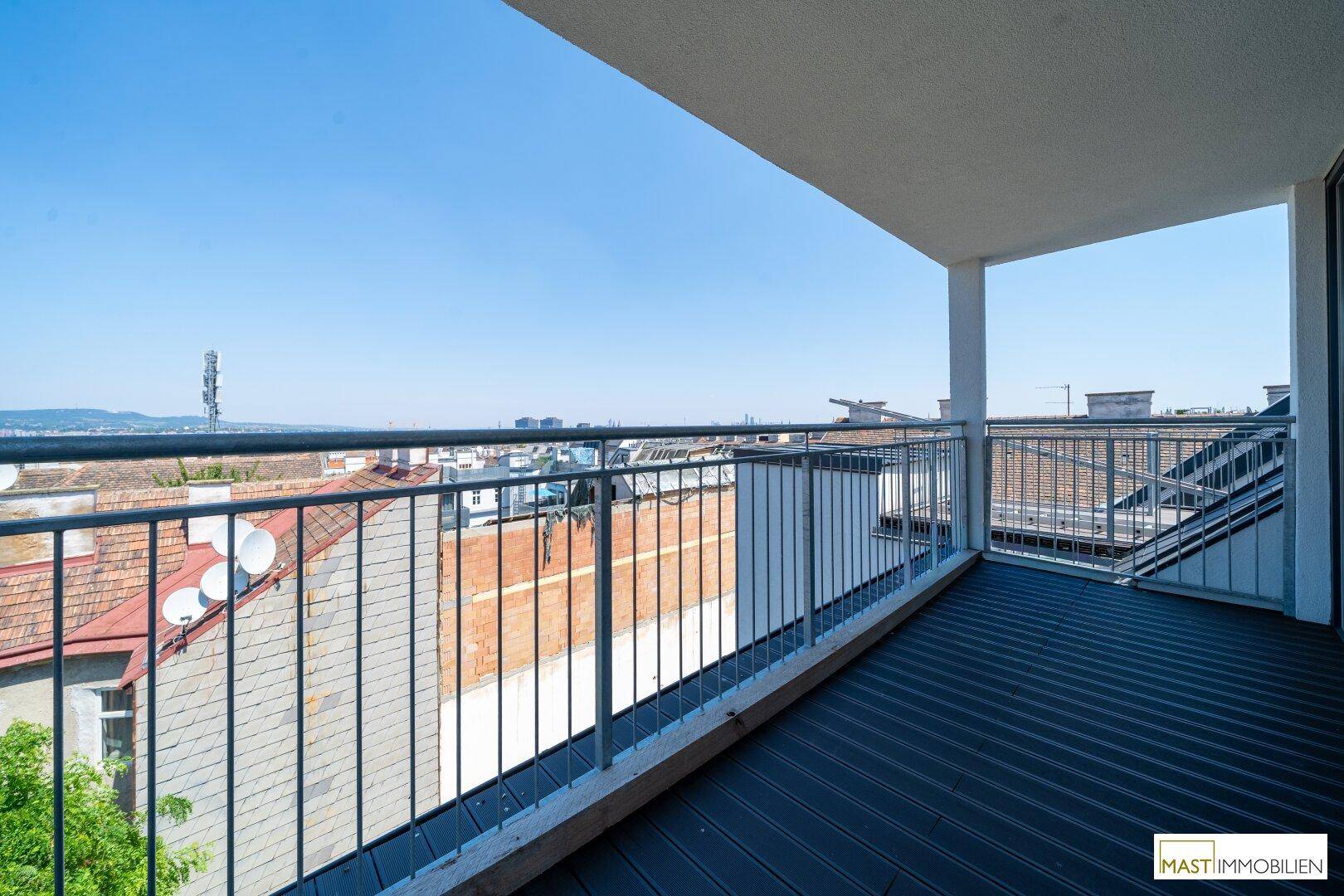 Breiter Balkon mit modernem Geländer und beeindruckendem Panoramablick über die Stadtlandschaft.