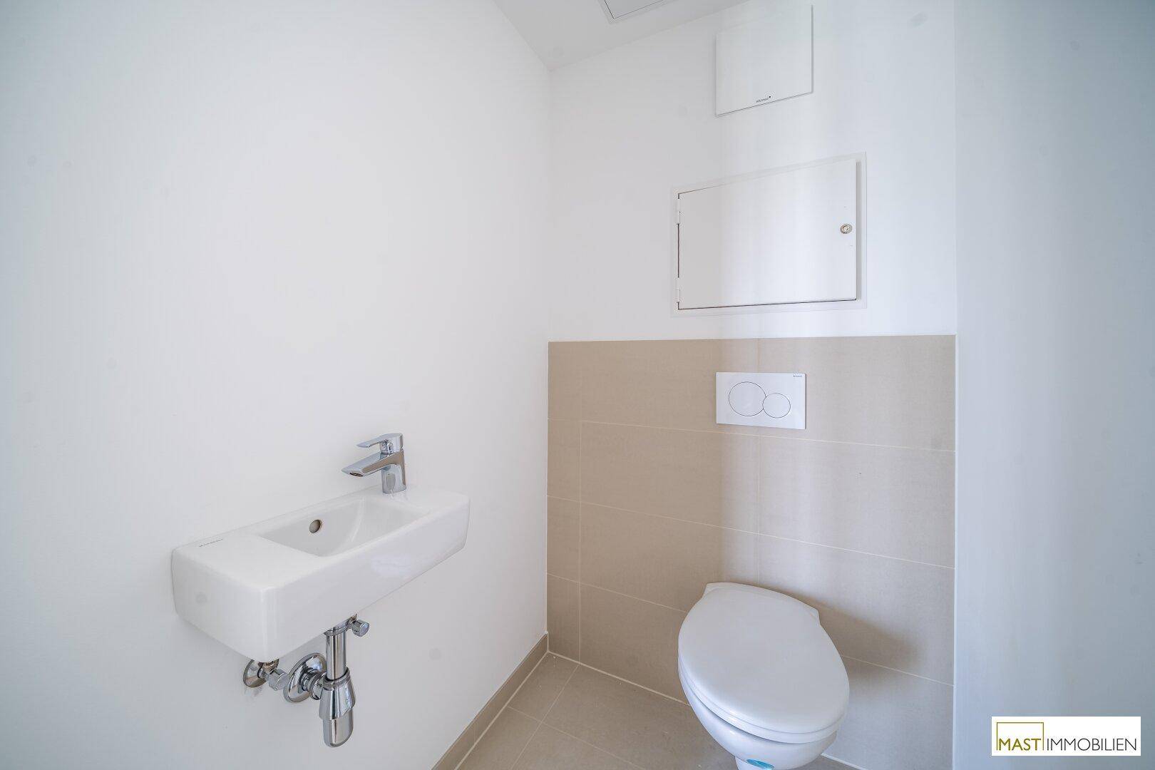 Modernes Gäste-WC mit wandhängendem WC und kleinem Waschbecken.