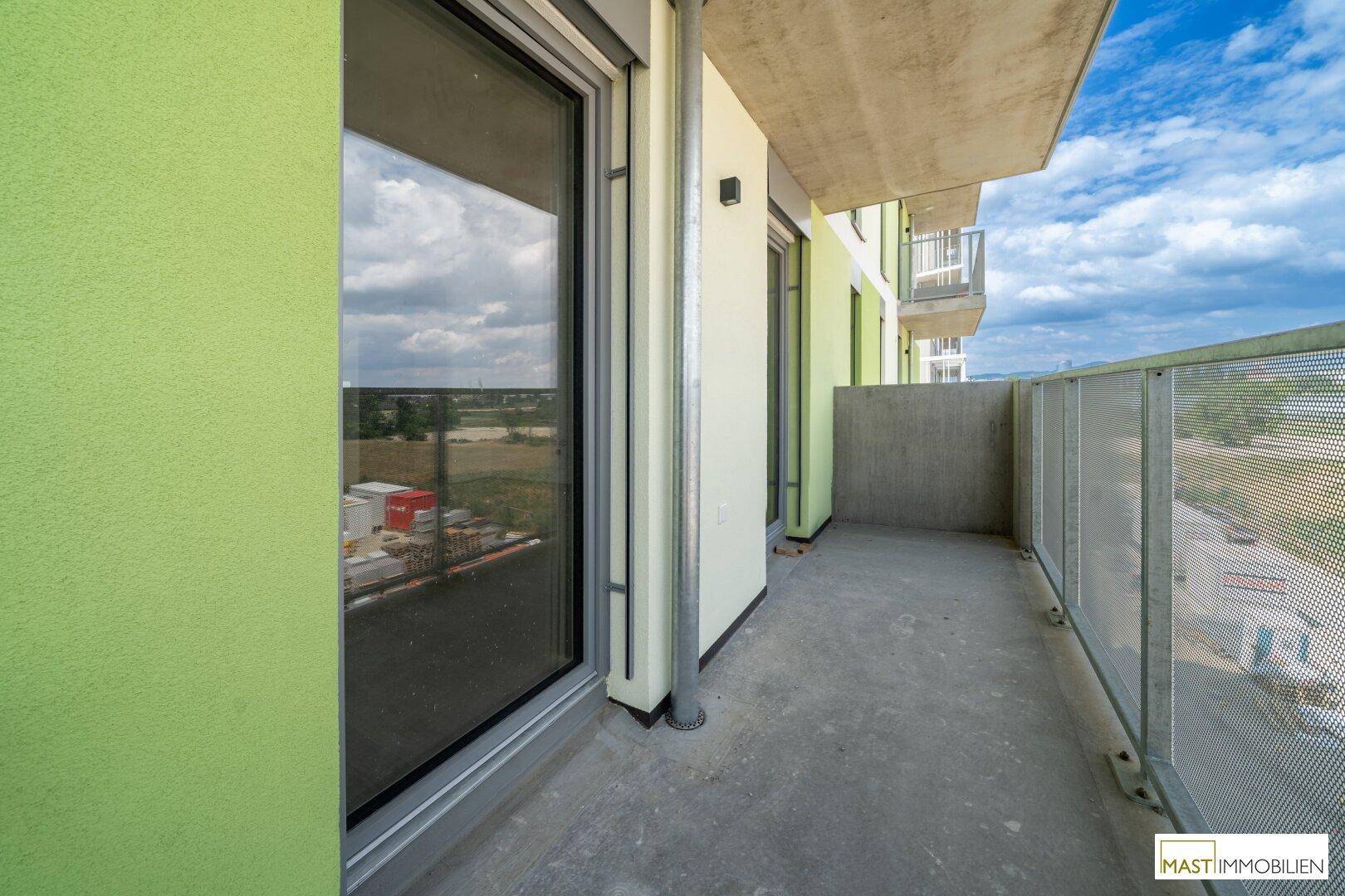 Langer Balkon mit Metallgeländer und Blick auf die Umgebung, ideal für entspannte Stunden.