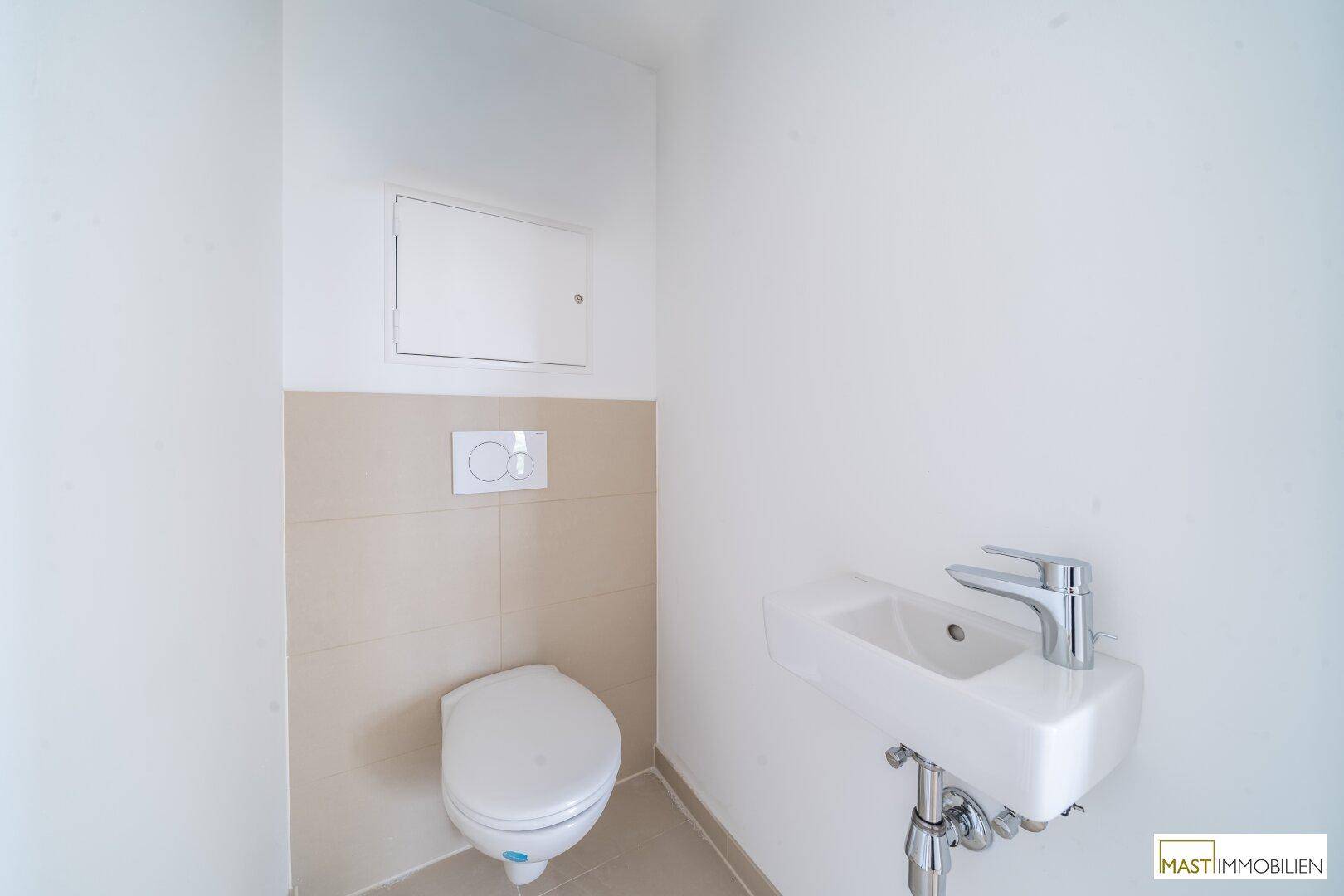 Kleines Gäste-WC mit wandhängender Toilette und einem kompakten Waschbecken.