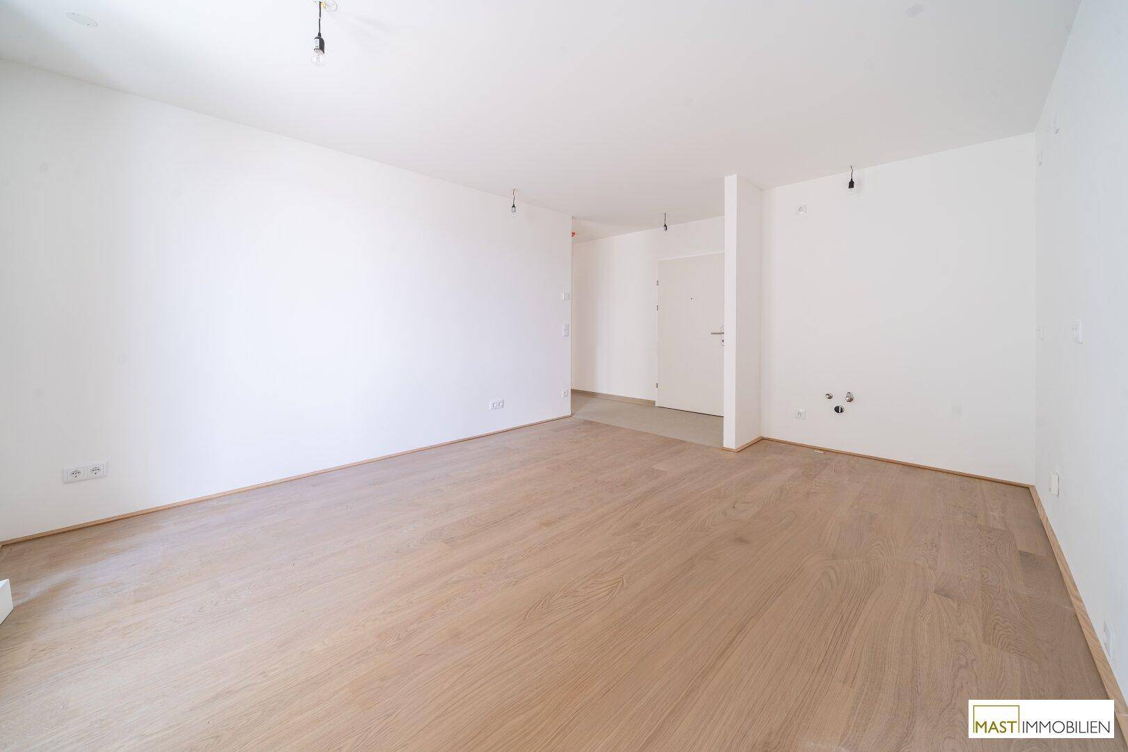 Geräumiges, helles Zimmer mit hellem Parkettboden und weiß gestrichenen Wänden, ideal für individuelle Gestaltung.