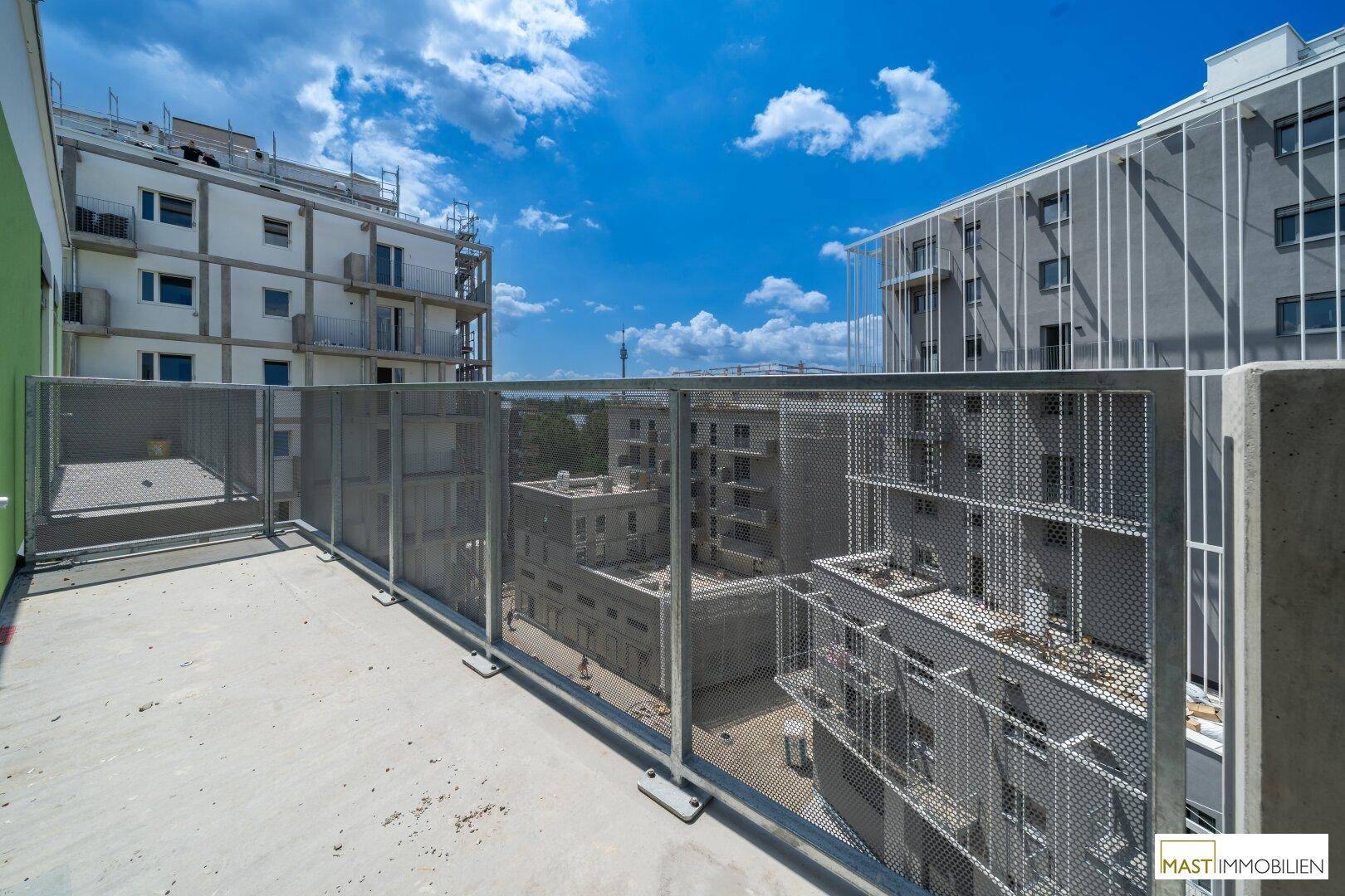 Offener Balkon mit moderner Metallbrüstung und Blick auf die städtische Umgebung.