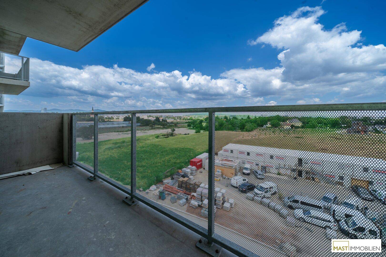 Geräumiger Balkon mit weitem Blick über grüne Felder und die umliegende Landschaft.